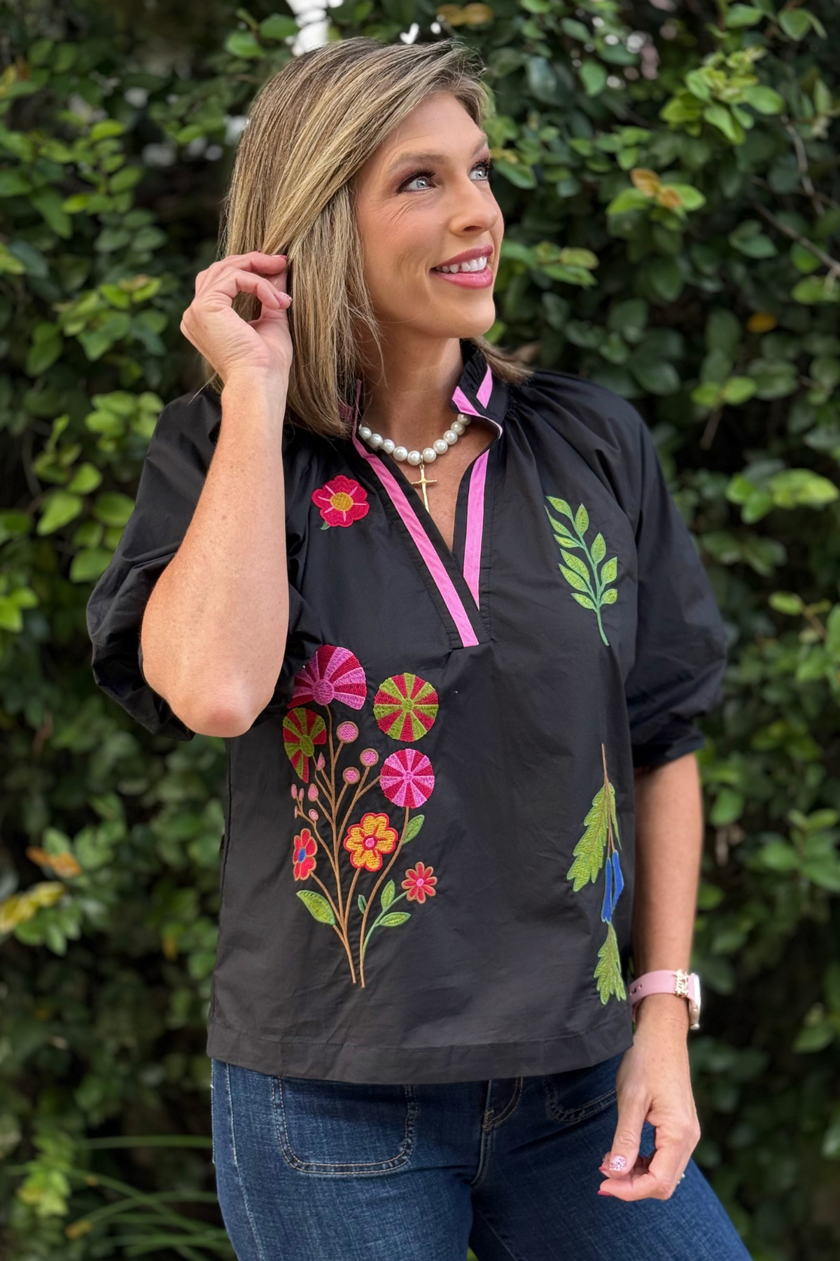 Model styling The Valencia Embroidered Blouse with dark denim — features multicolor floral embroidery and ¾ puff sleeves.