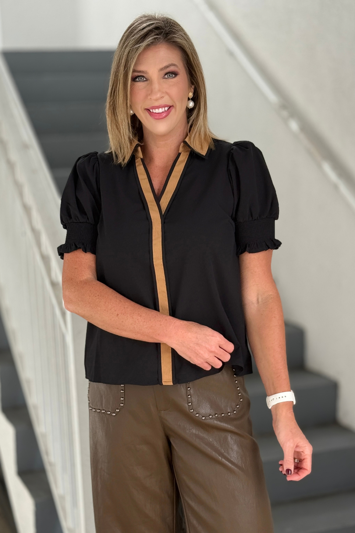 Women's black blouse with tan collar and V-neck trim