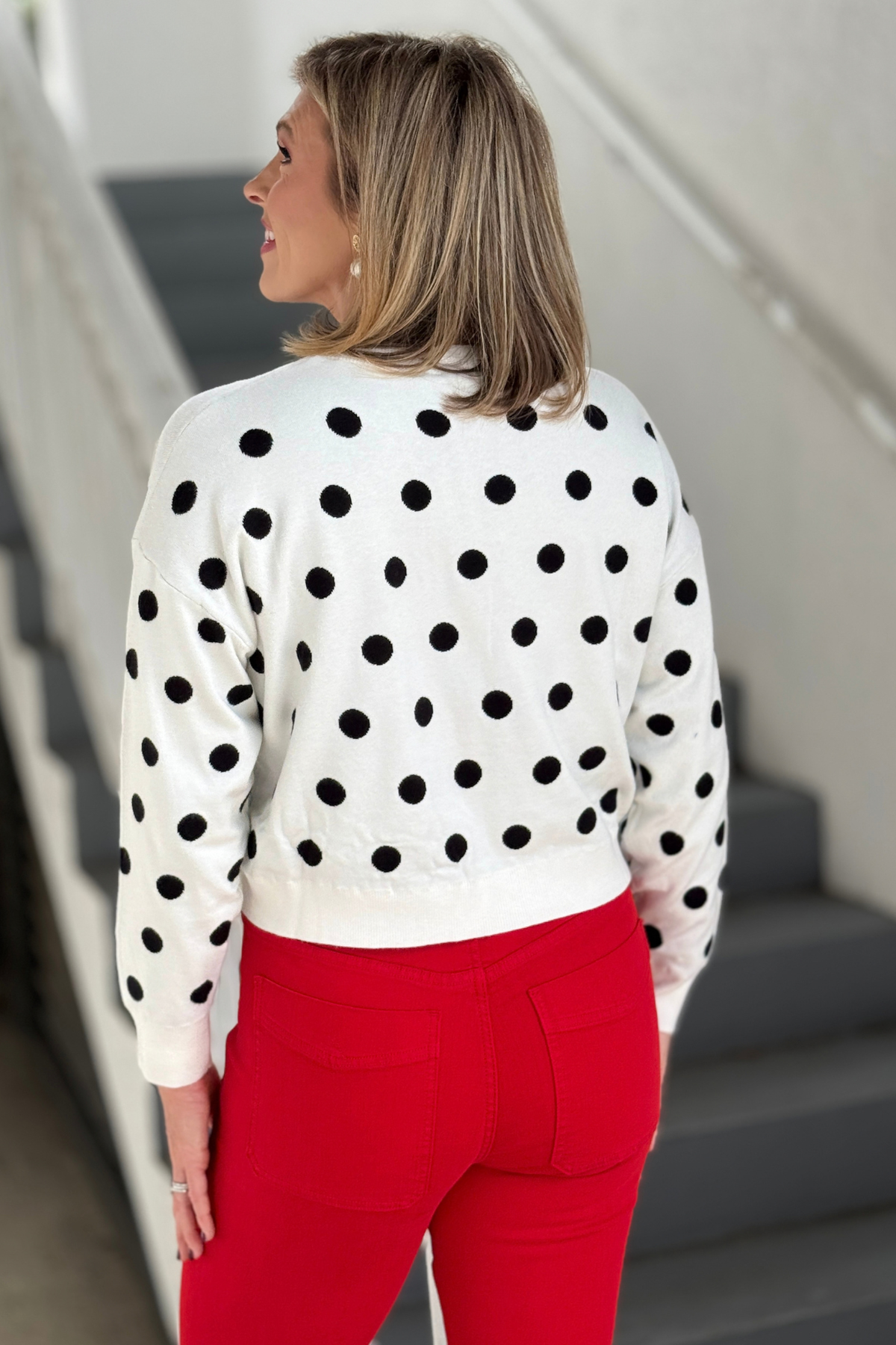 Polka dot front knot sweater styled with red denim
