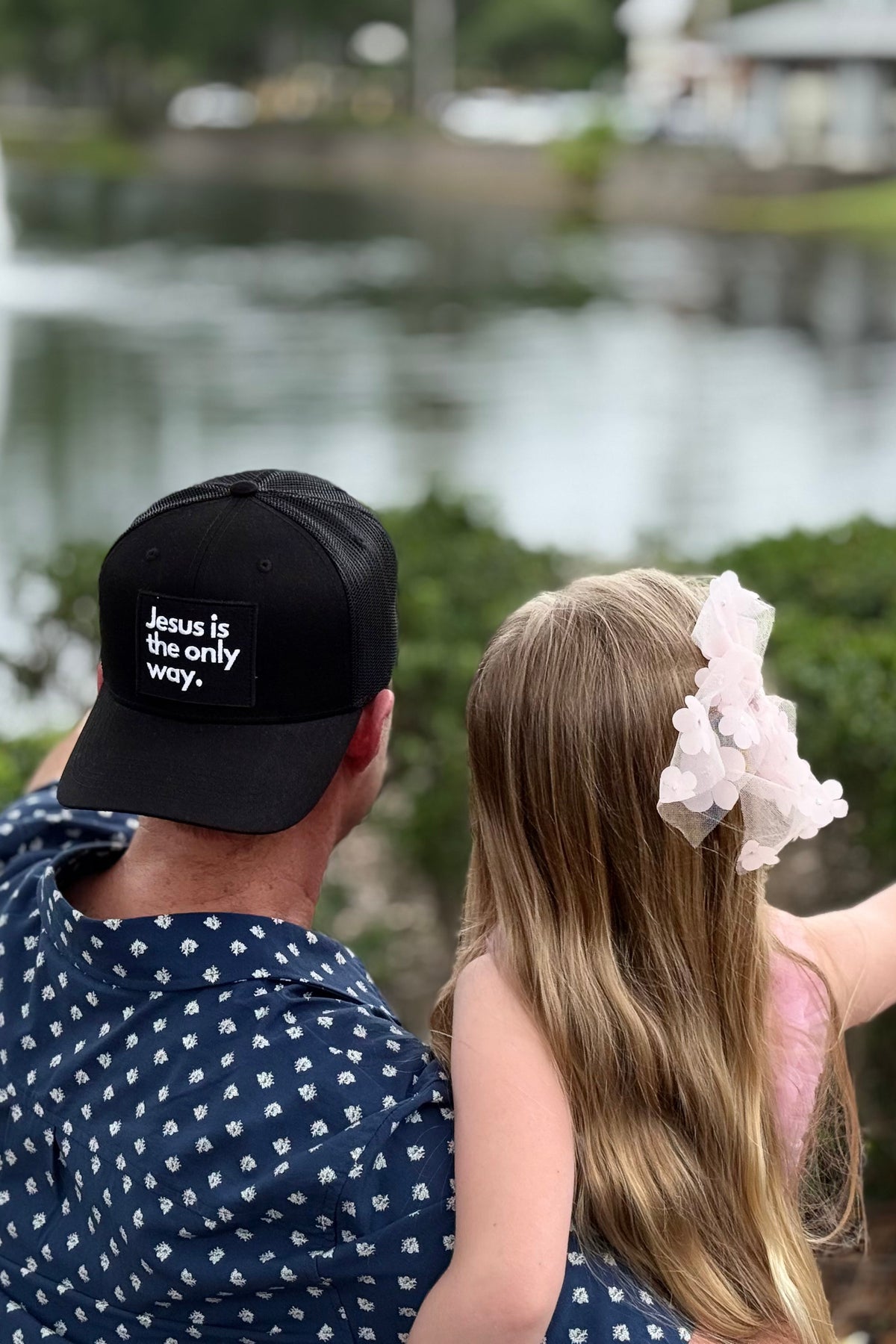 Dad and Daughter looking off in distance while man wears ballcap backwards
