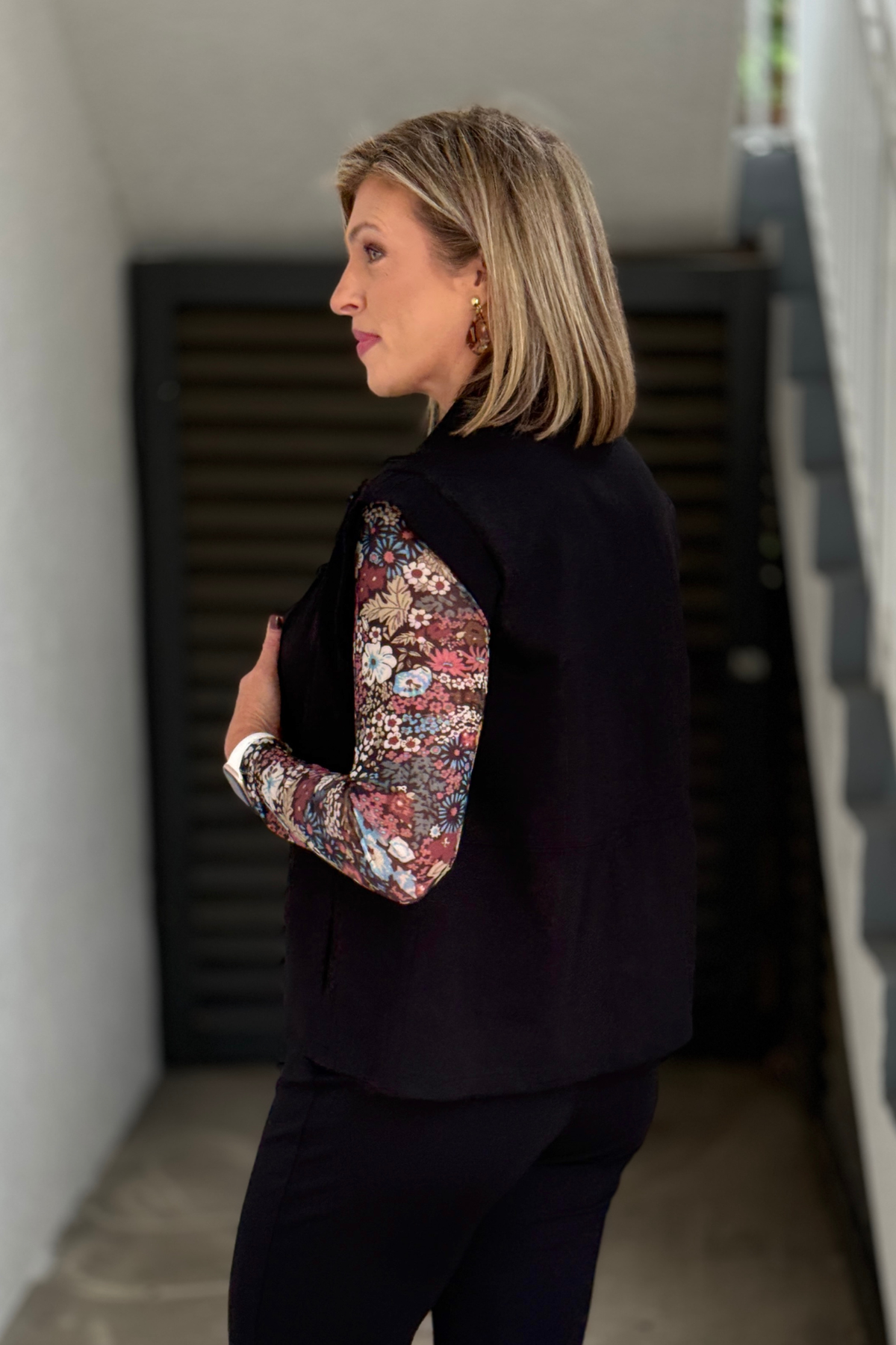 Women’s black everyday vest styled over Charlie B floral mesh top