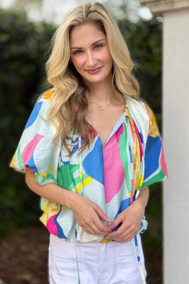 Front view of bright pleated crop top with tie neck strings
