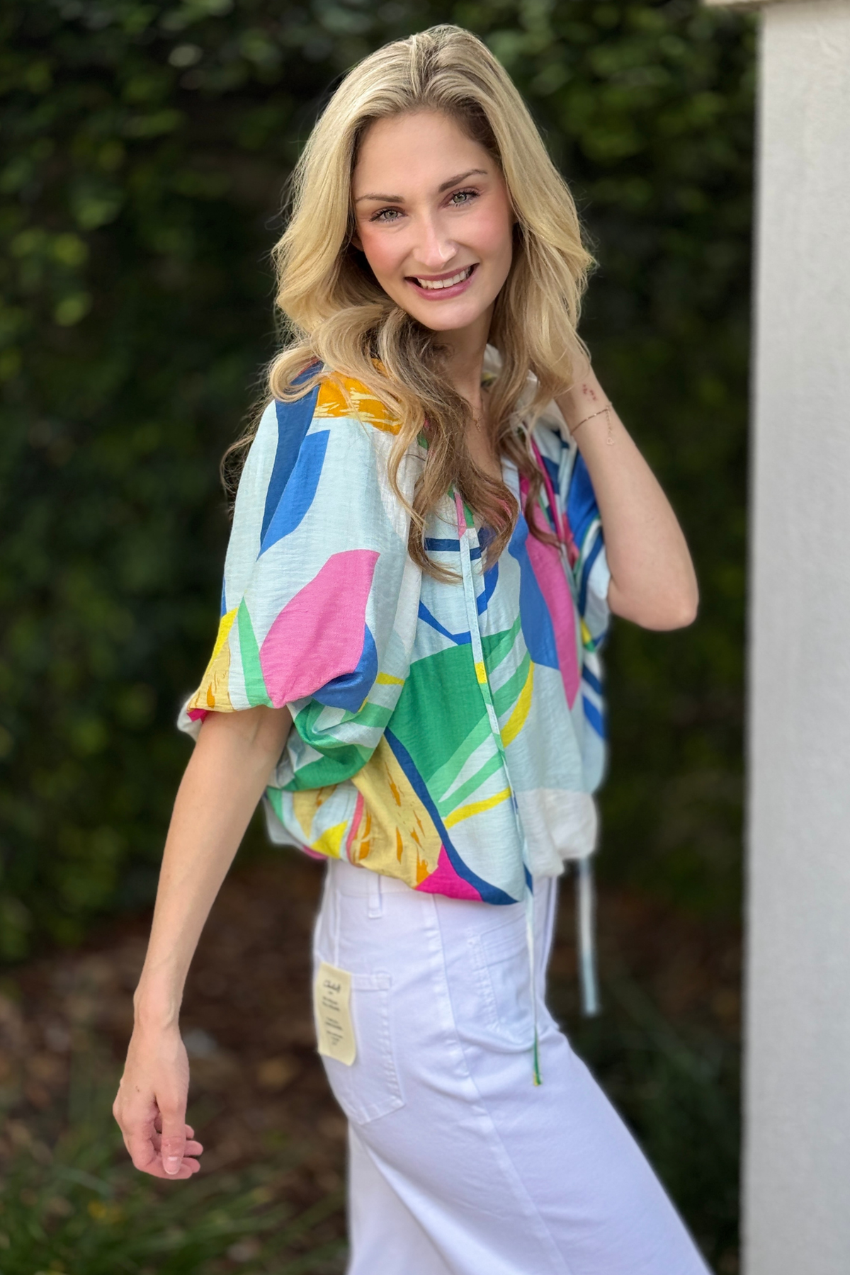 Women’s boutique abstract balloon sleeve top styled with white pants