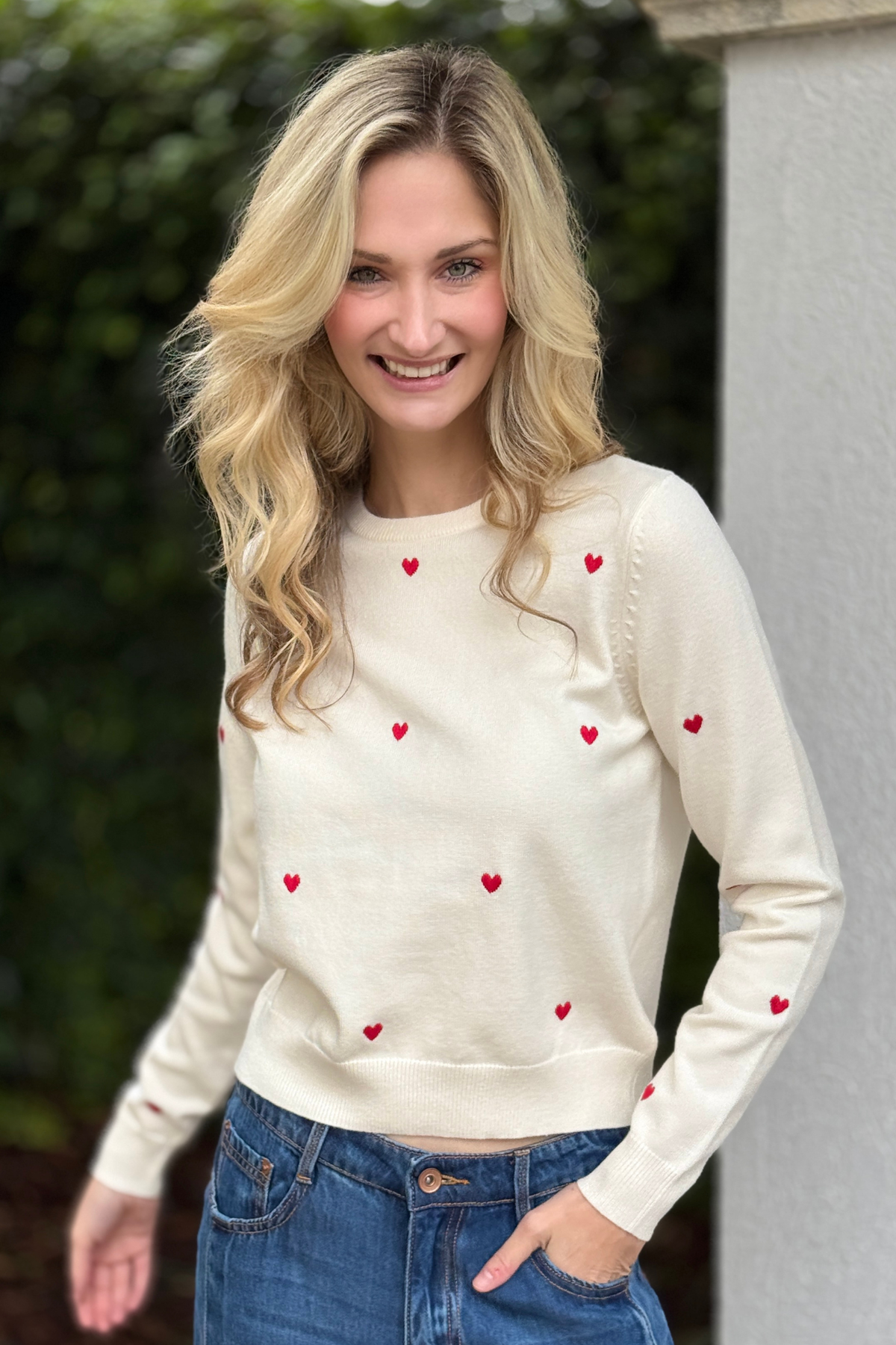 Back view of white sweater with red heart embroidery