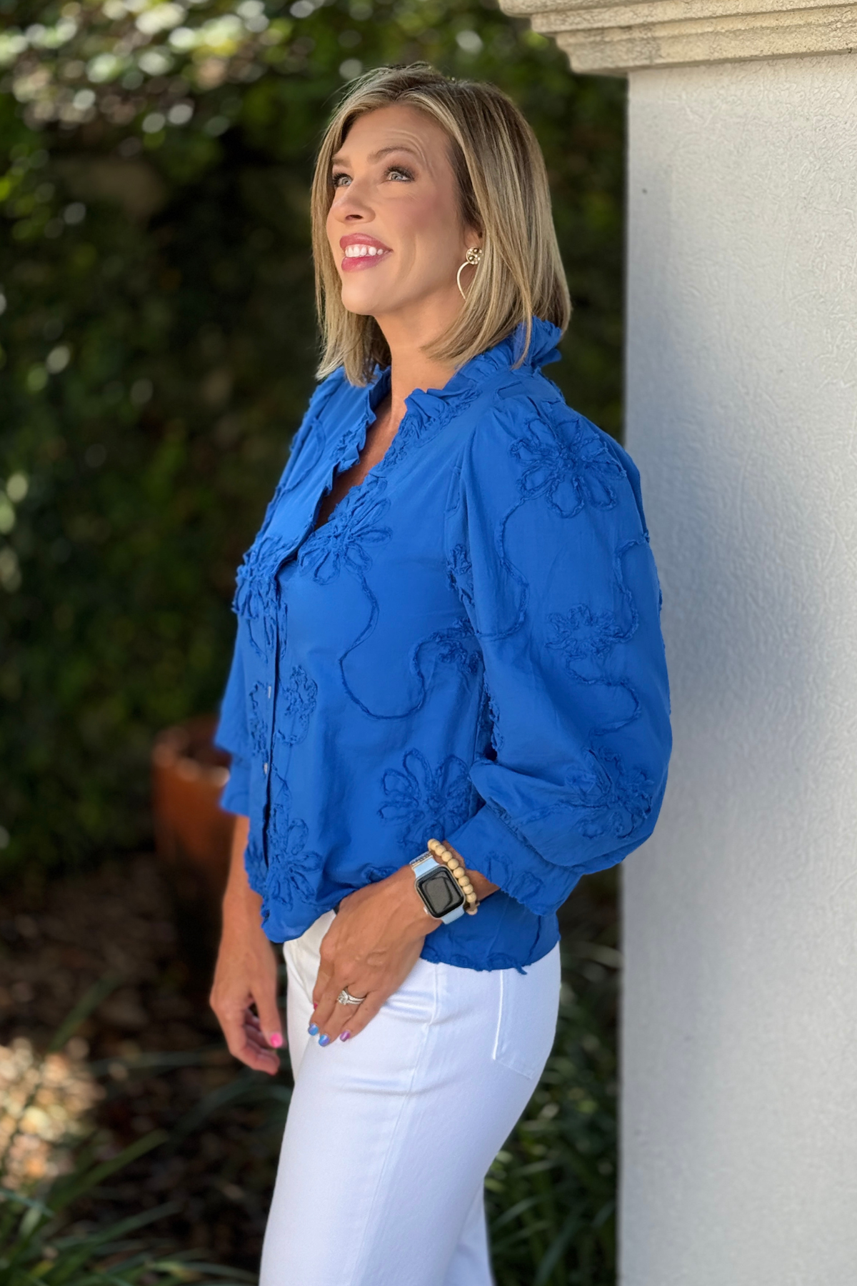 Royal blue ruffle neck button top styled with white denim