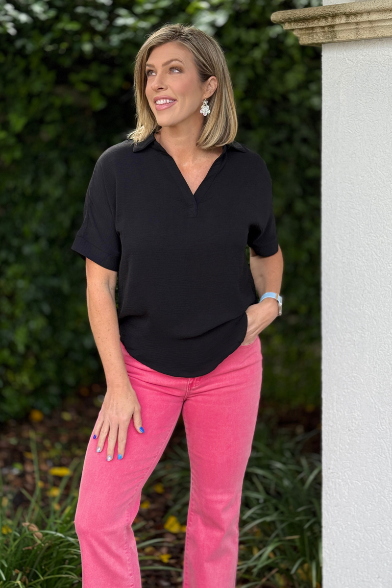 woman wearing black breezy airflow blouse with pink jeans