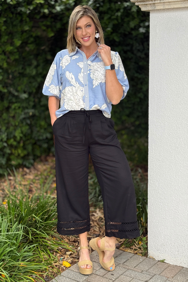 Model wearing black wide leg cropped pants with floral blouse
