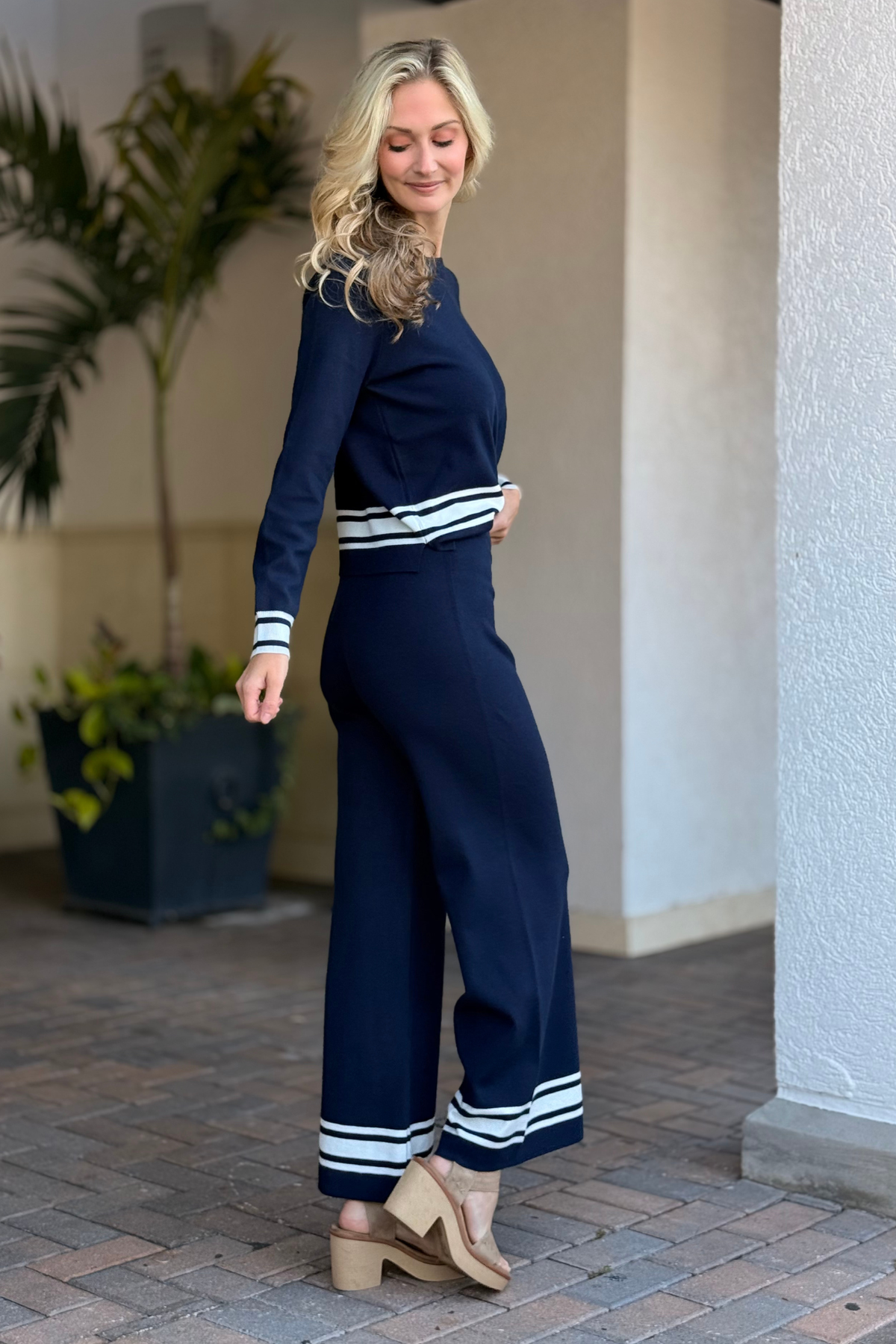 Full-length view of navy knit pants with sporty stripe hem