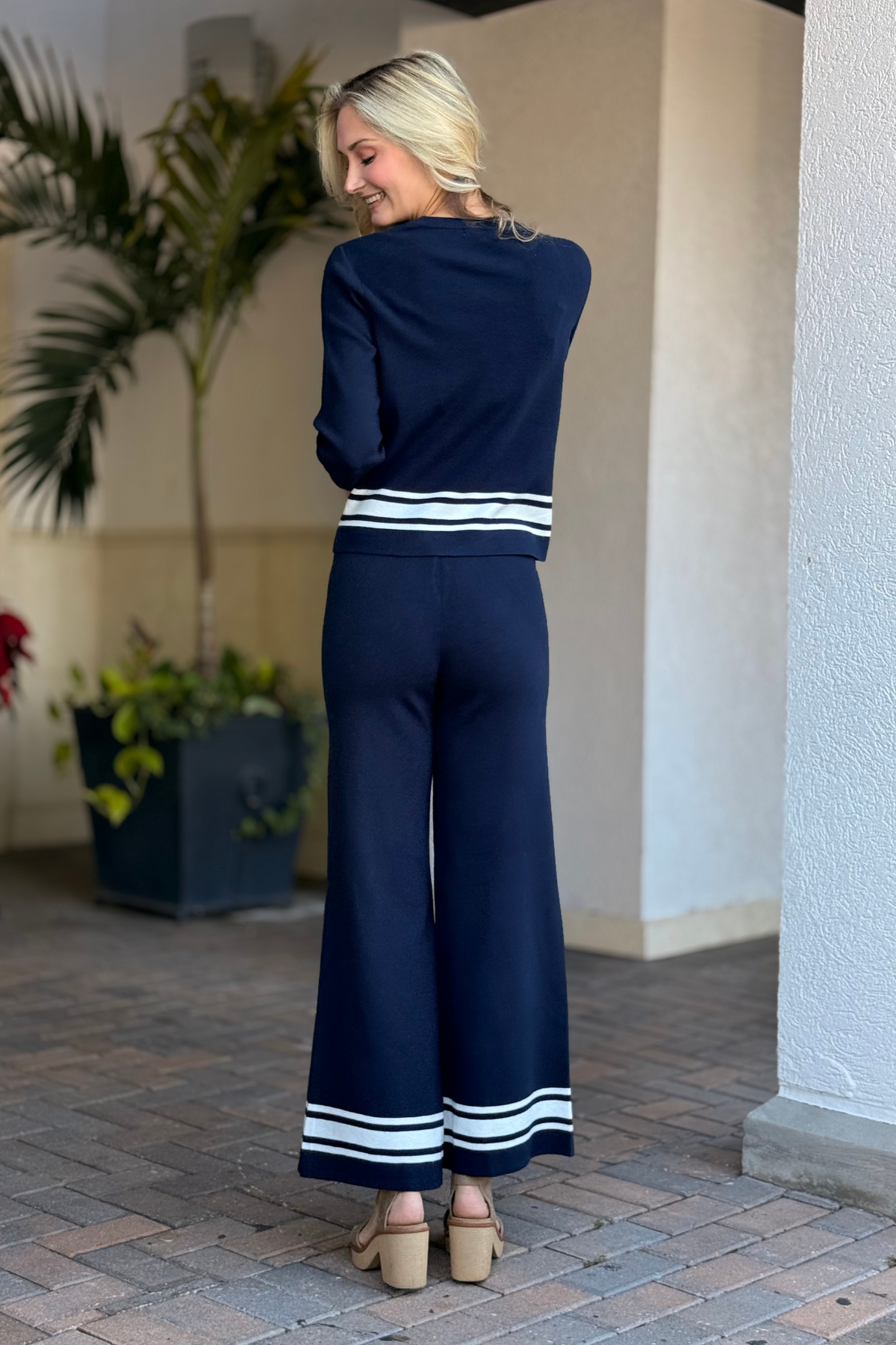 Lifestyle photo of model styling The Blue Tide Stripe Knit Pant outdoors