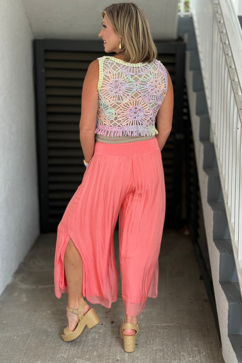 Back view of lightweight coral silk resort pants with elastic waistband