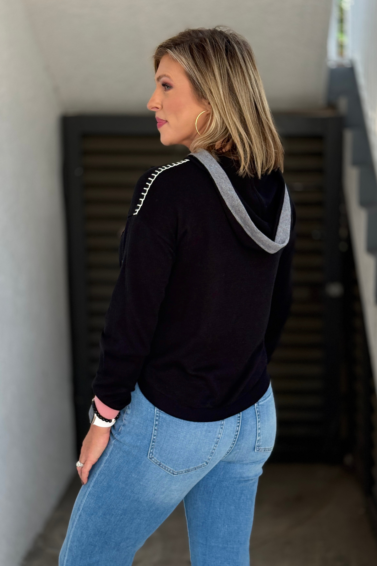 Back view of Charlie B black hooded sweater with gray contrast hood