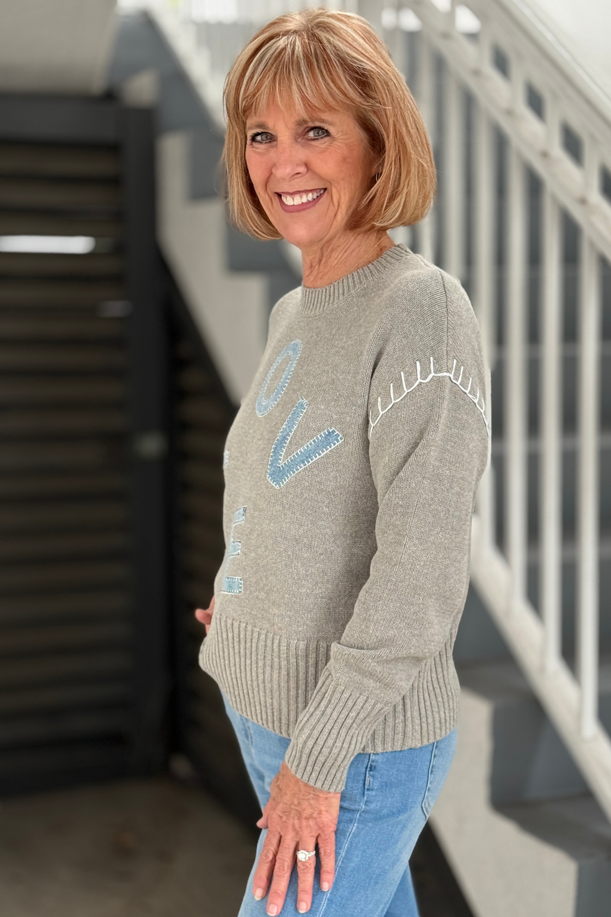 Side view of denim LOVE patch sweater by Charlie B