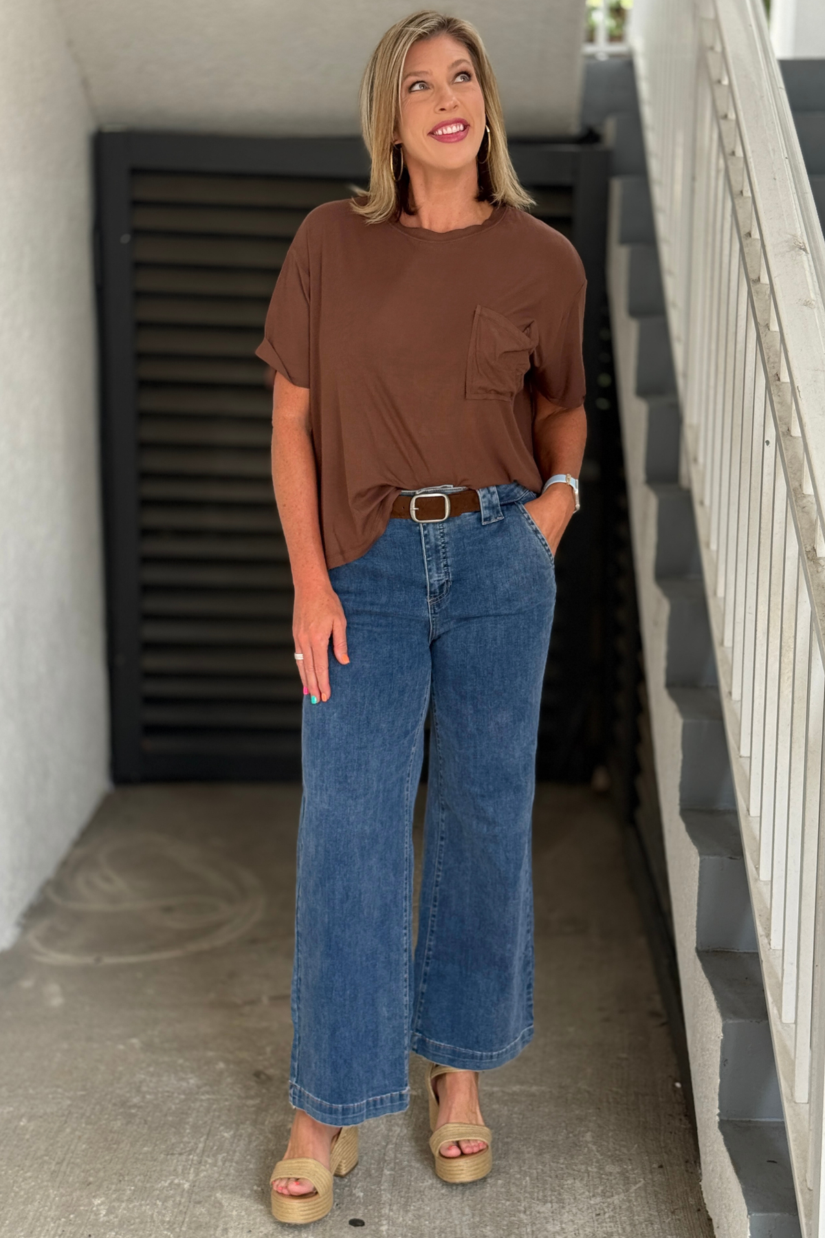 Front view of medium blue wide leg jeans with removable brown belt