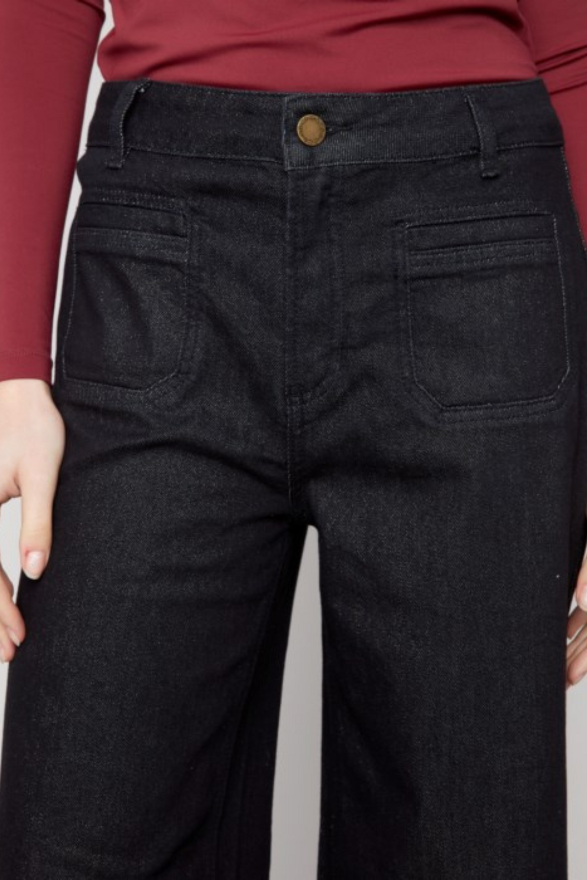 Close-up of Charlie B black flare jeans with front patch pockets and subtle lurex stitching.