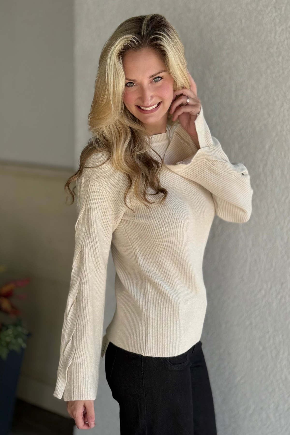 Close-up of Charlie B ribbed knit sweater in H. Oat with cable design on sleeves