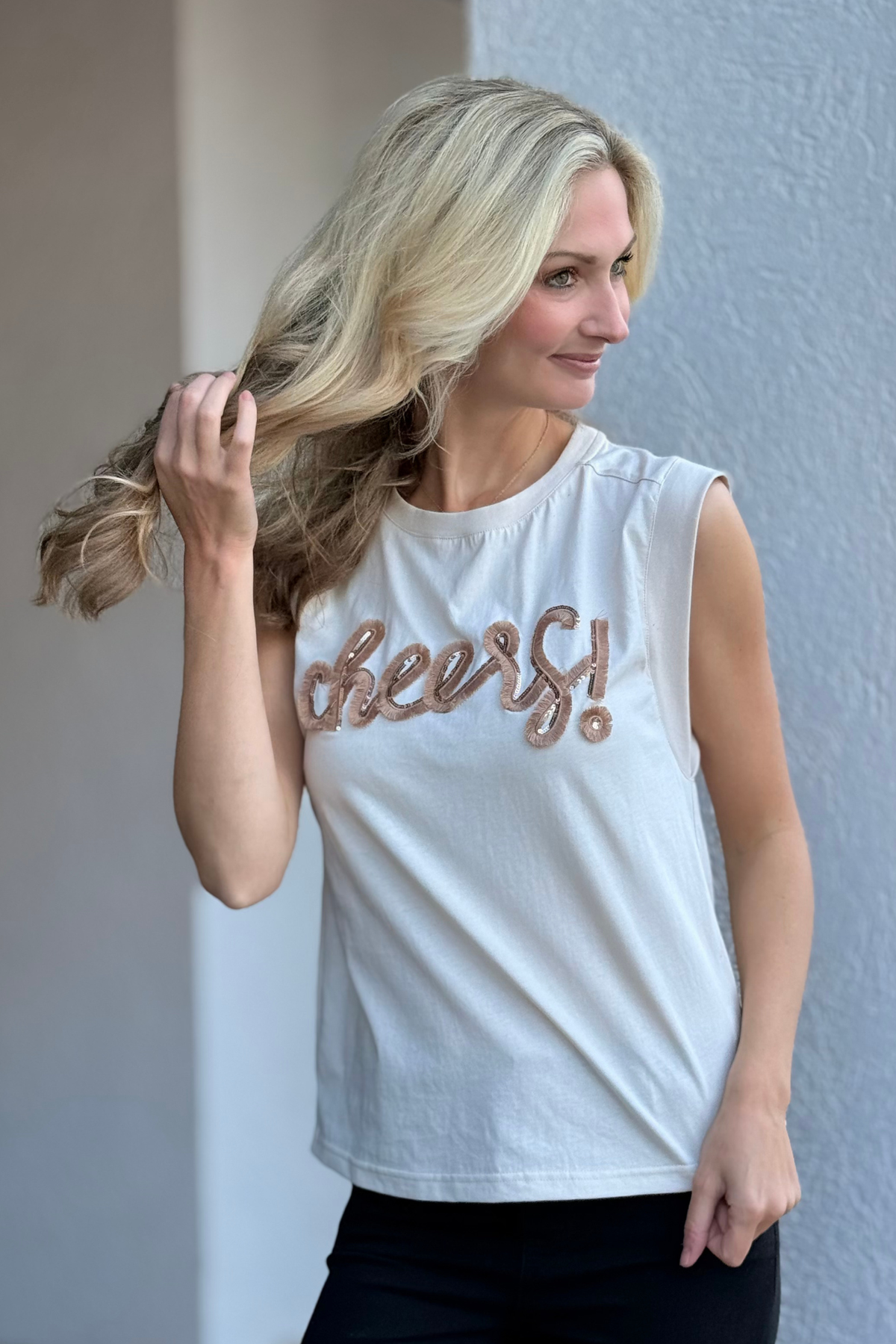 Neutral embroidered cheers top styled with black pants