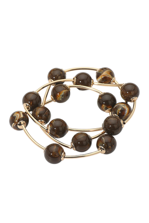 Close-up of brown wire and bead layered bracelets