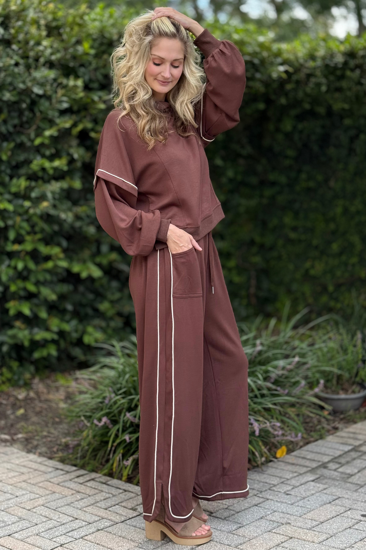 Side view of Cocoa Crush Brown Knit Pants showing contrasting piping along legs and hem