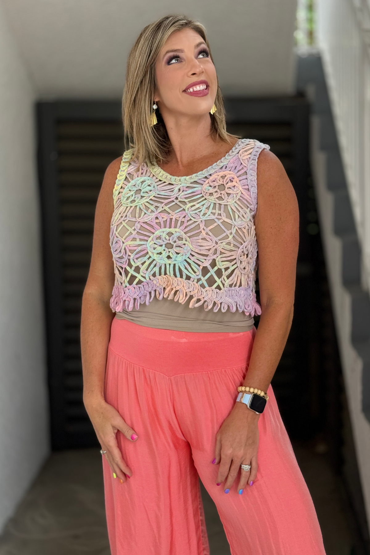 Side view of pastel crochet tank top layered over a neutral cami