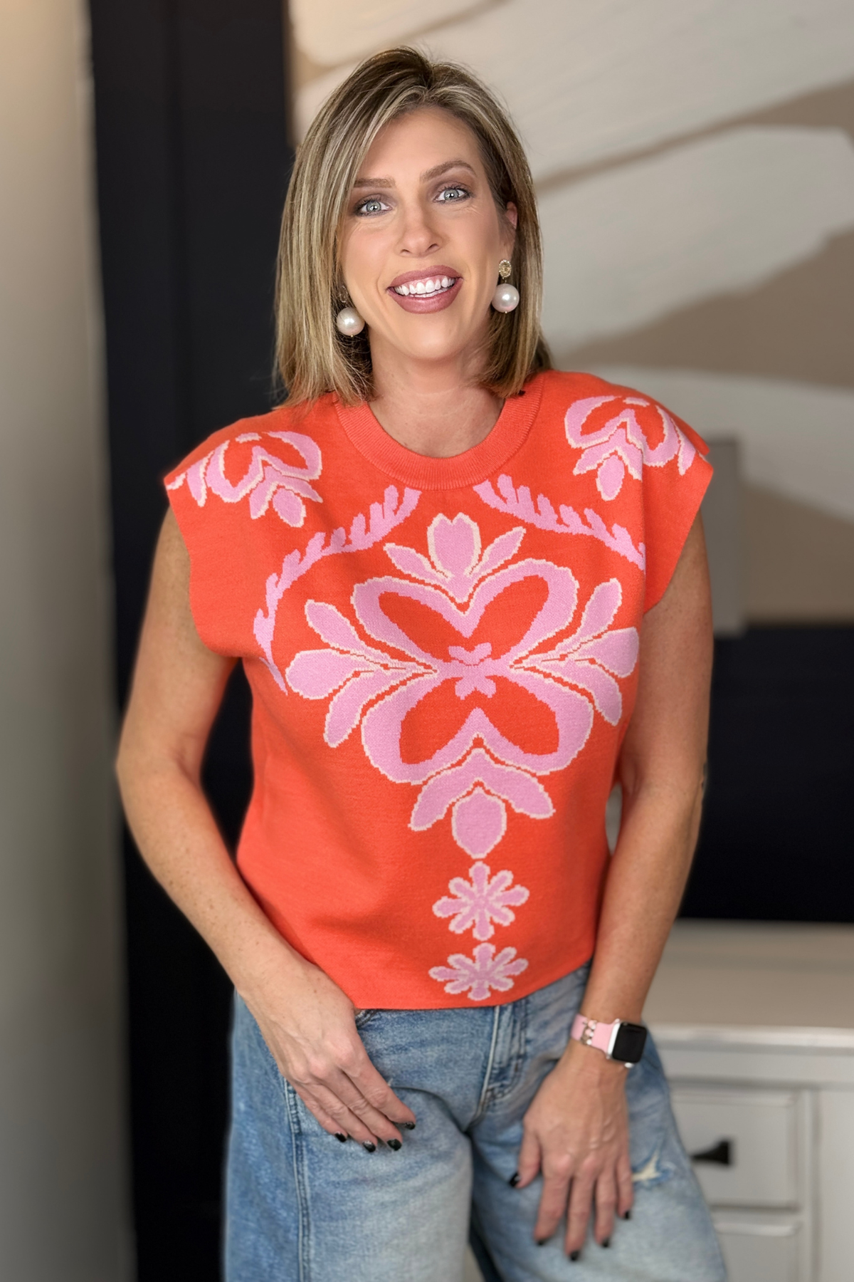 model wearing coral patterned sleeveless knit top front view