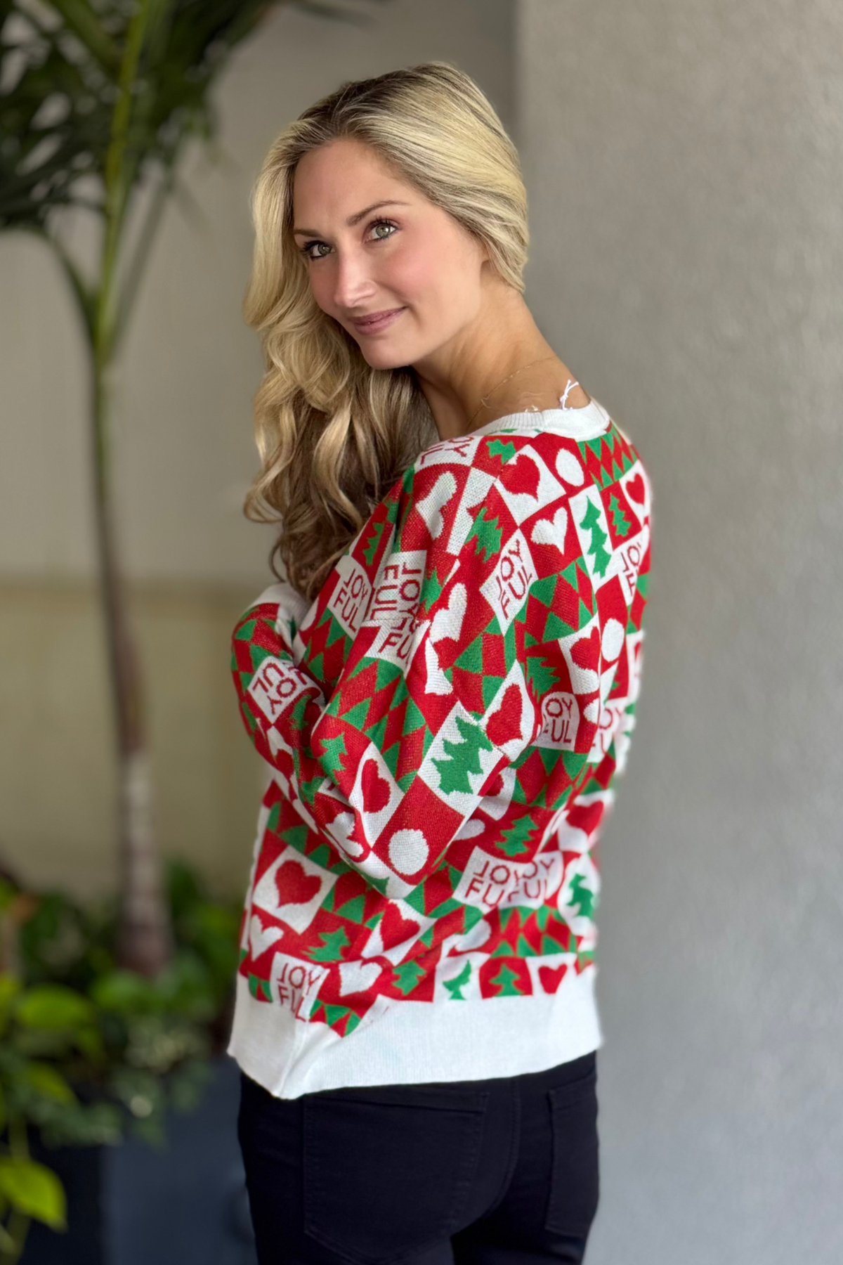 Holiday knit sweater featuring playful Christmas motifs worn during the festive season.