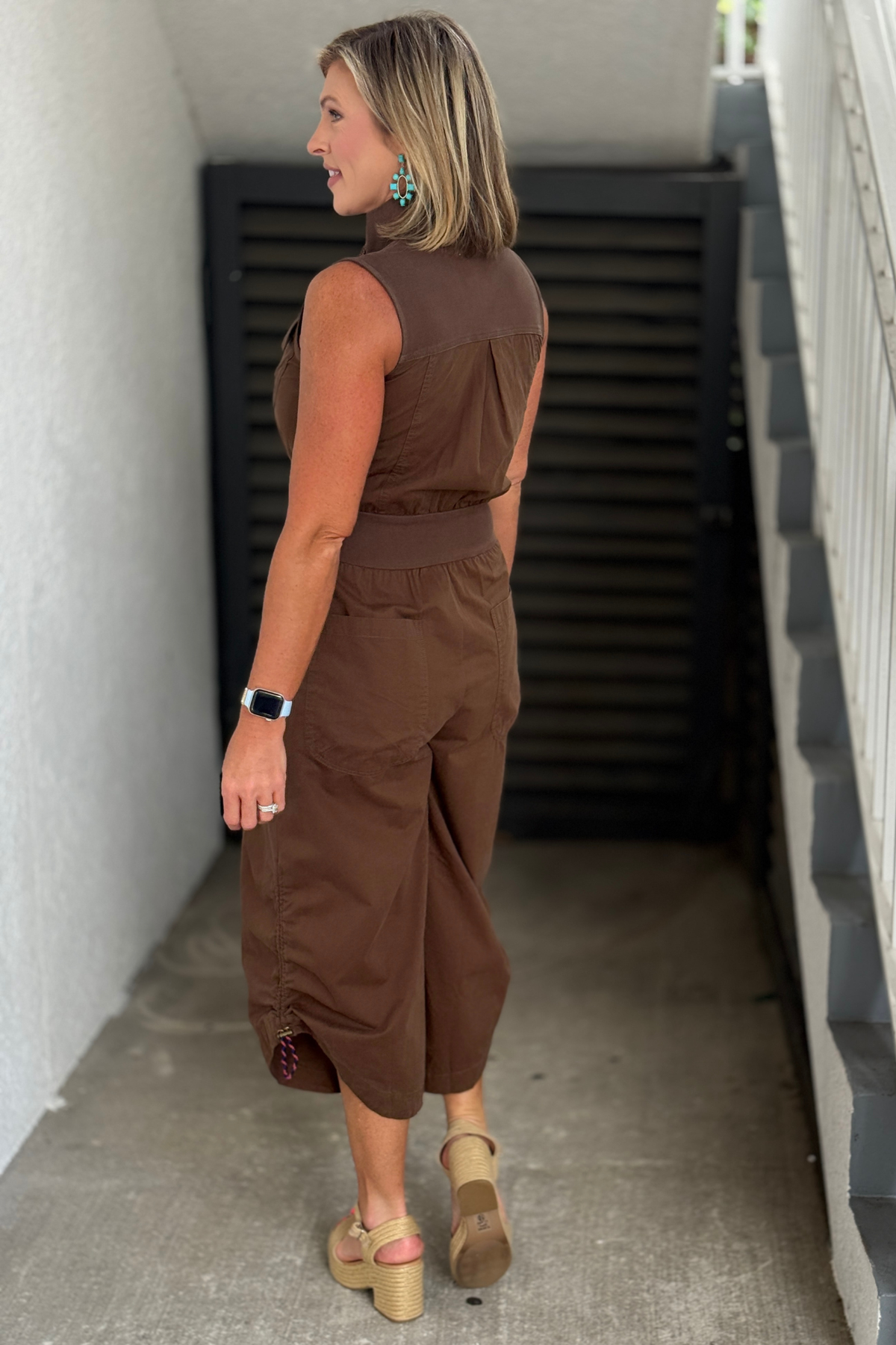 Casual sleeveless mocha jumpsuit styled with wedges.