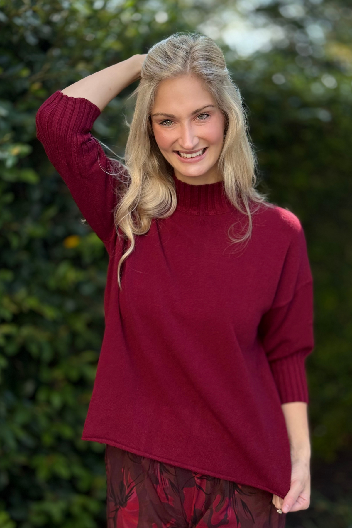 Side angle showing relaxed fit and ribbed mock neckline of burgundy sweater