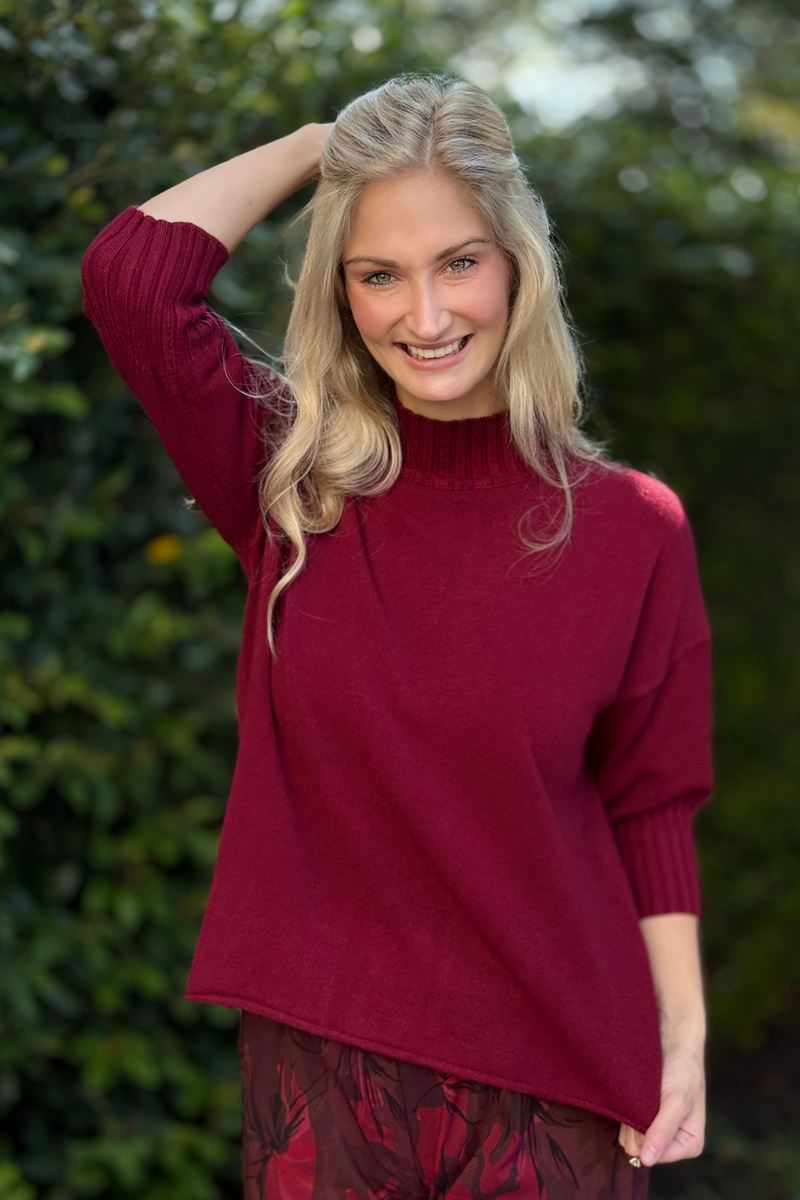 Side angle showing relaxed fit and ribbed mock neckline of burgundy sweater