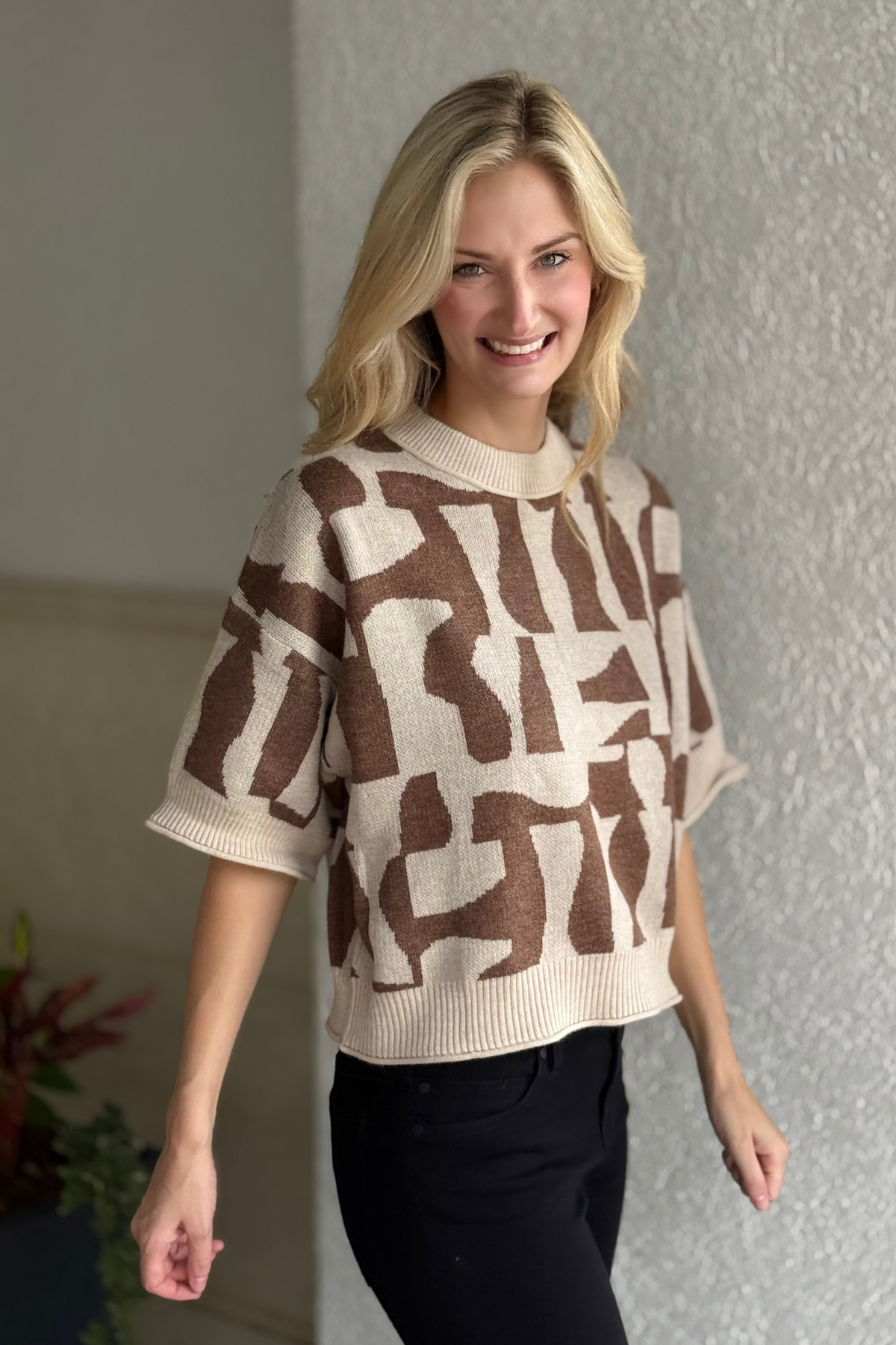 Side view of brown abstract sweater showing lightweight knit texture