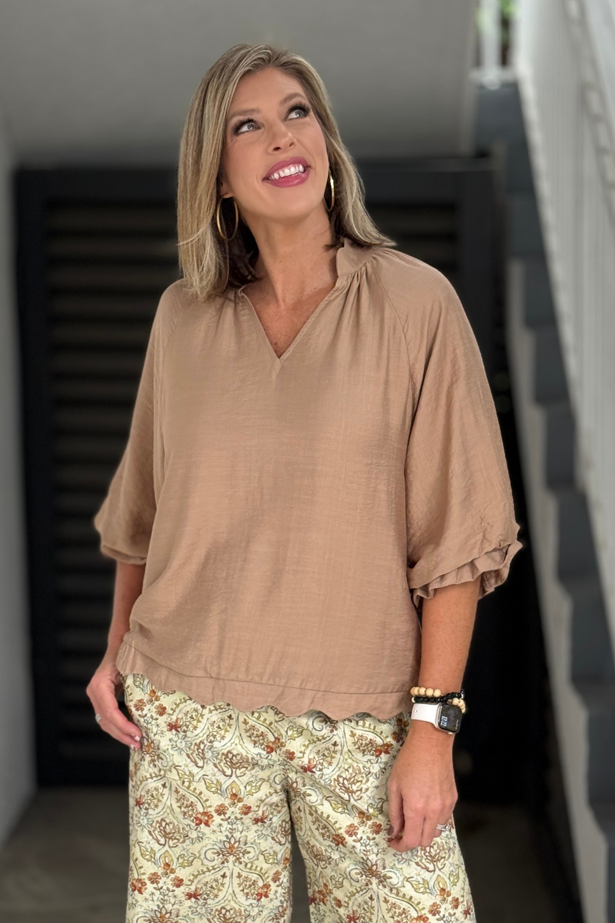 Women’s neutral V-neck blouse styled with paisley pants