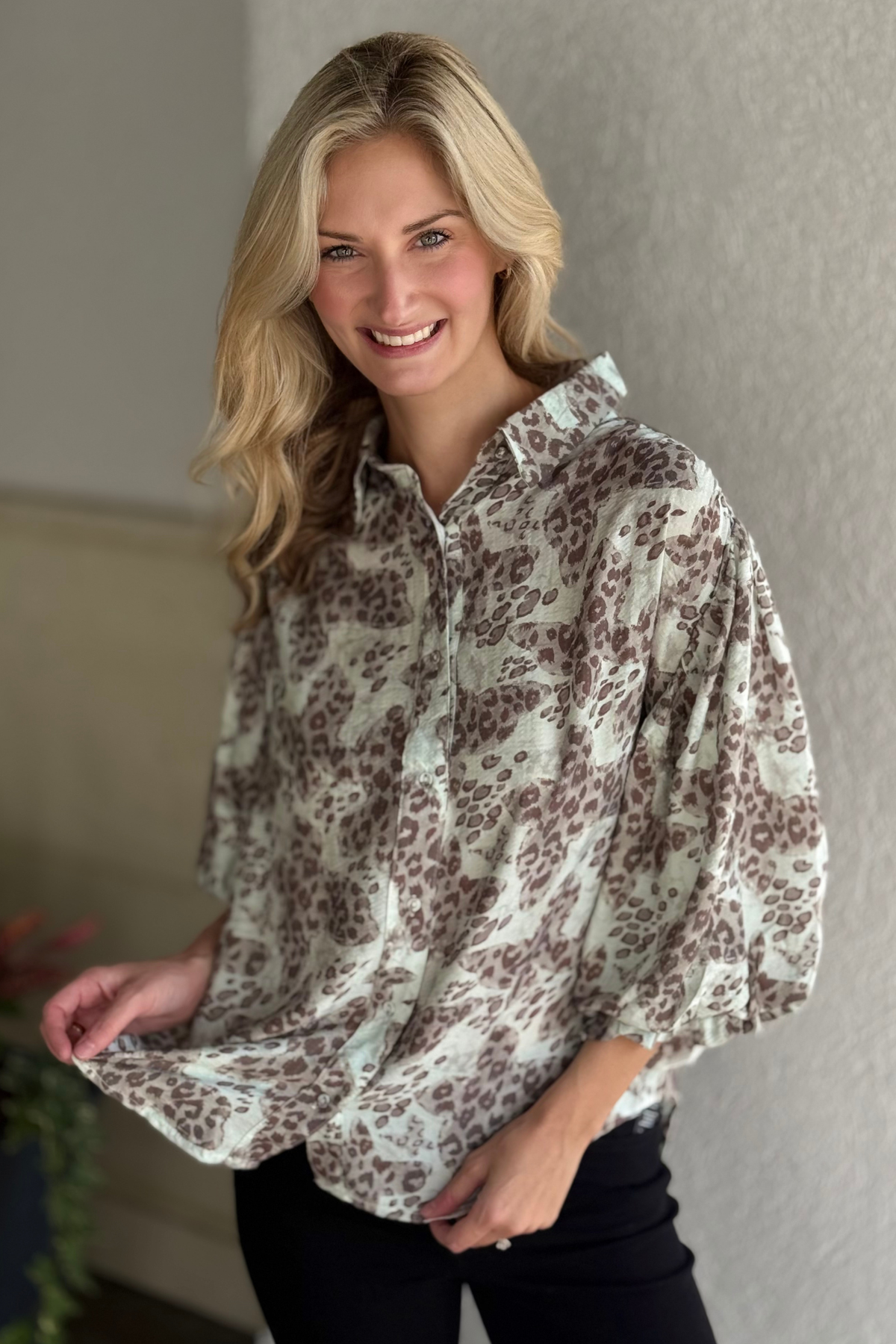 Model wearing the Barely Wild Popover Top, a muted leopard print button-down blouse with 3/4 balloon sleeves from The Pink Nickel.