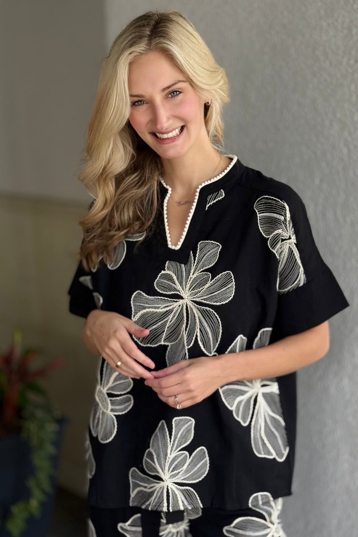 Model wearing Vineyard Petal Embroidered Popover Top in black with ivory floral embroidery