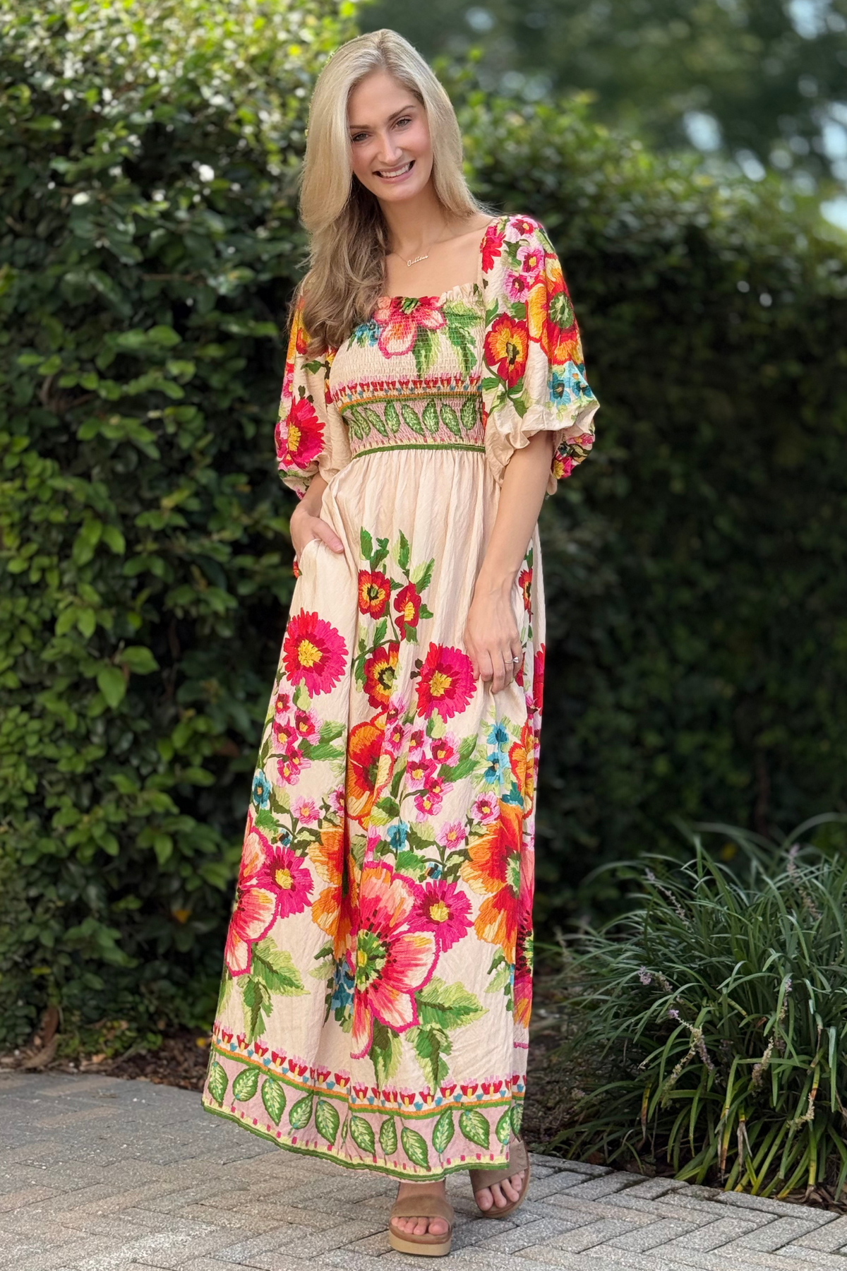 Front view of model wearing giant floral border smocked maxi dress with bubble sleeves