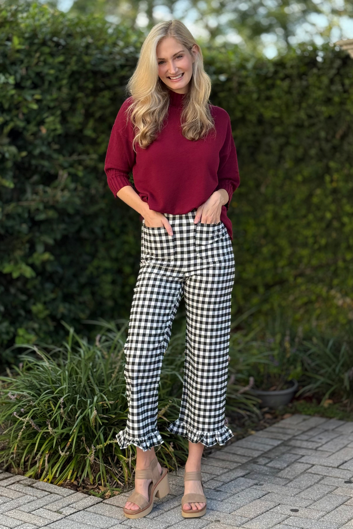 Front view of model wearing black gingham ruffle trim straight leg pants