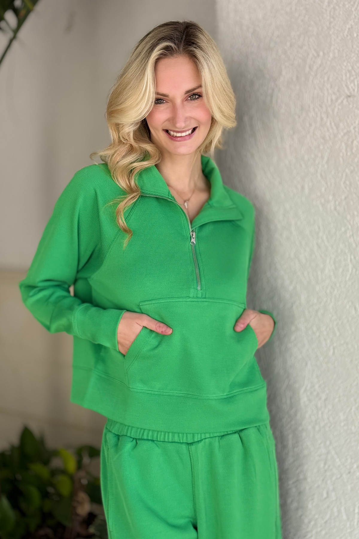 Model wearing pop green ribbed lounge set with 1/4 zip sweater