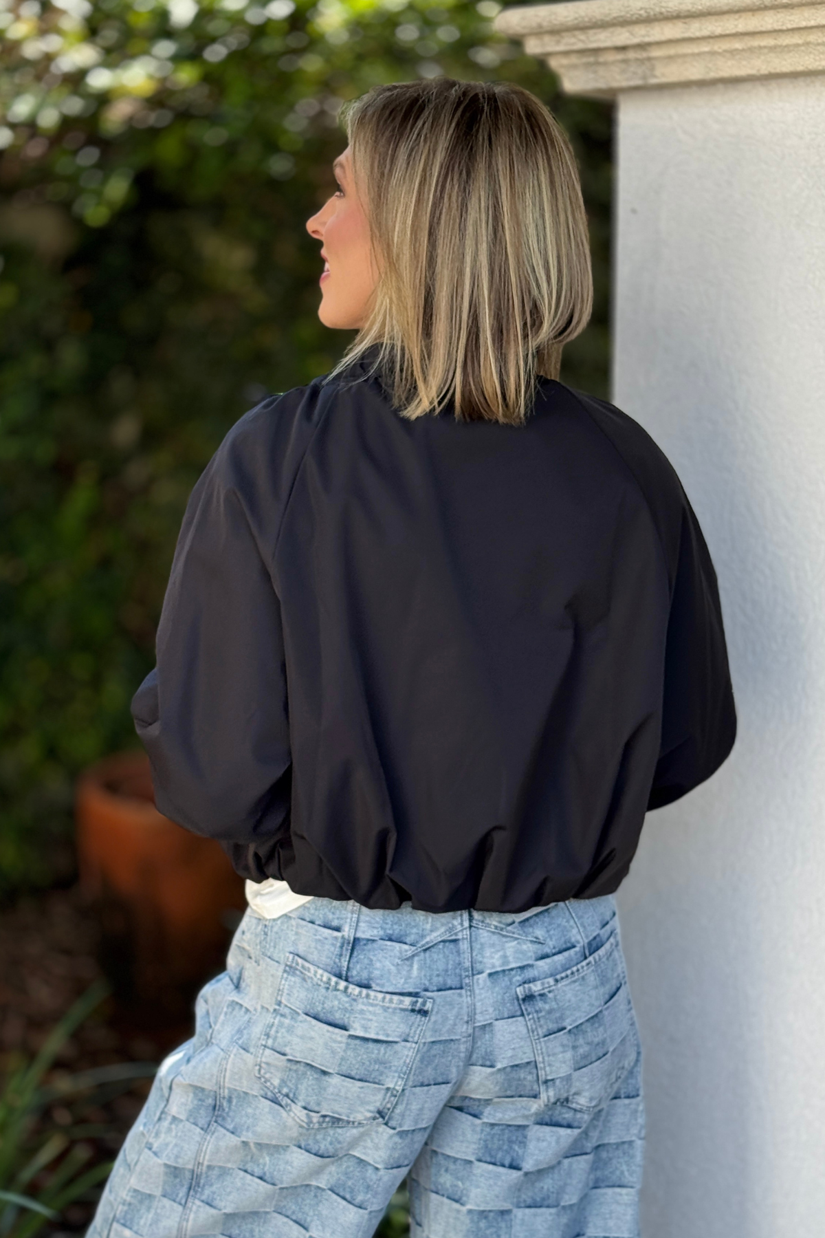 Back view of black one size jacket with bubble hem