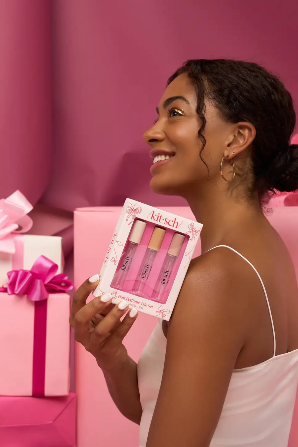 Kit-sch hair perfume trio in Warm Sugar, Amber Shores, and Rustic Vanilla displayed on pink gift box