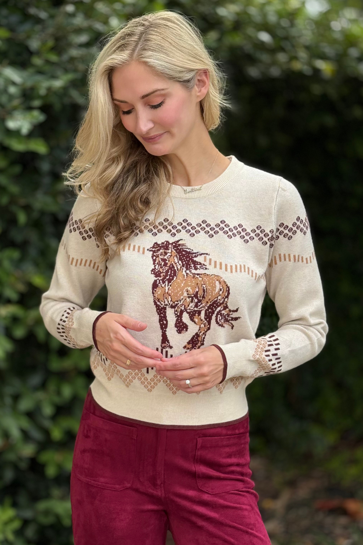 Side view of Western Horse Motif Knit Sweater styled with burgundy pants