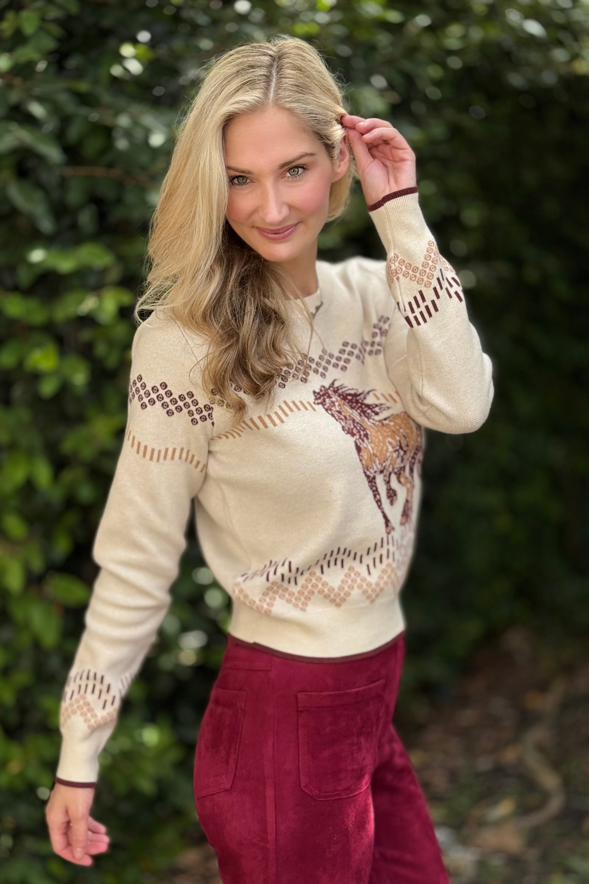 Side view of Western Horse Motif Knit Sweater styled with burgundy pants