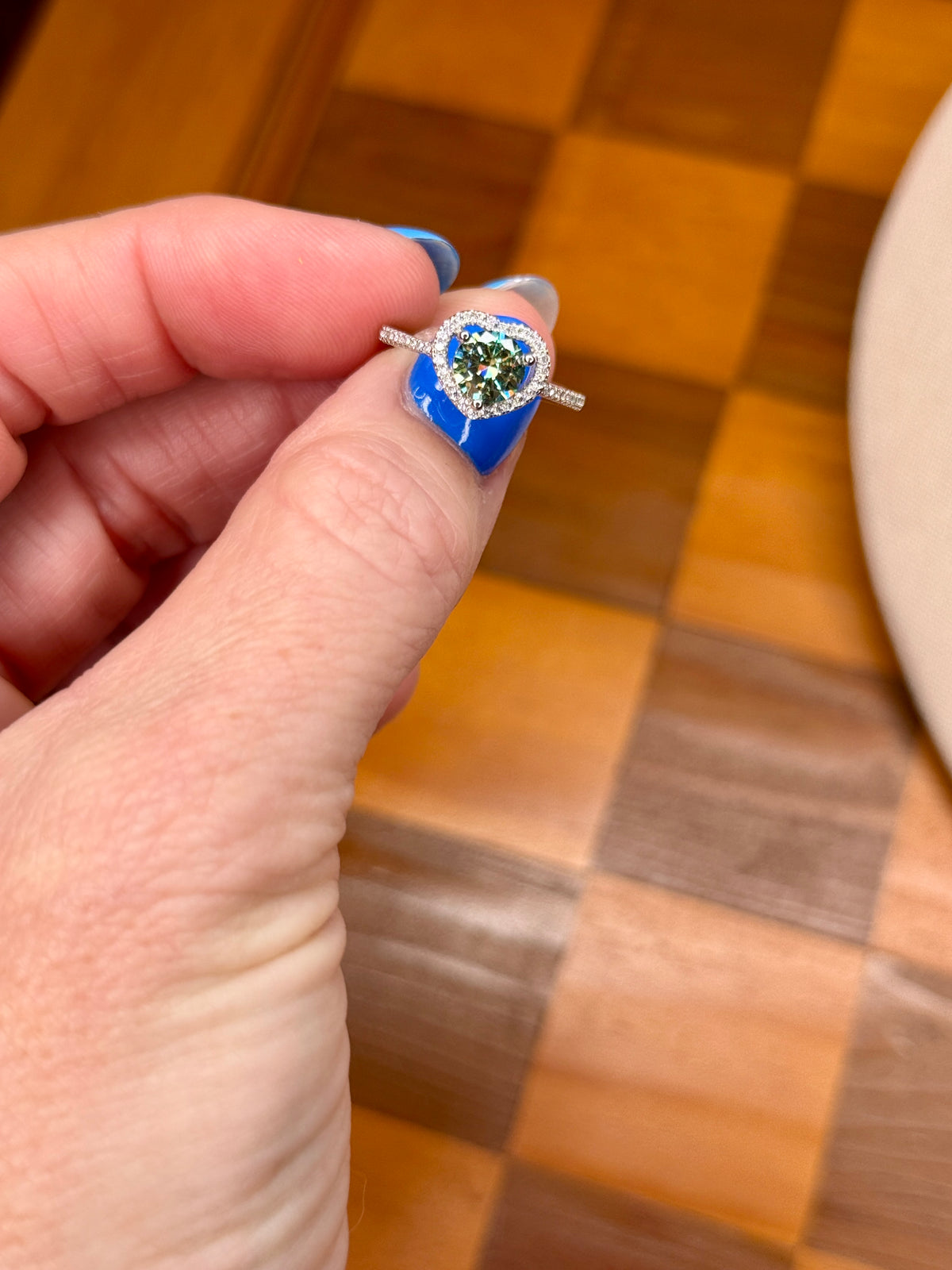 heart shaped moissanite ring with halo on finger close up