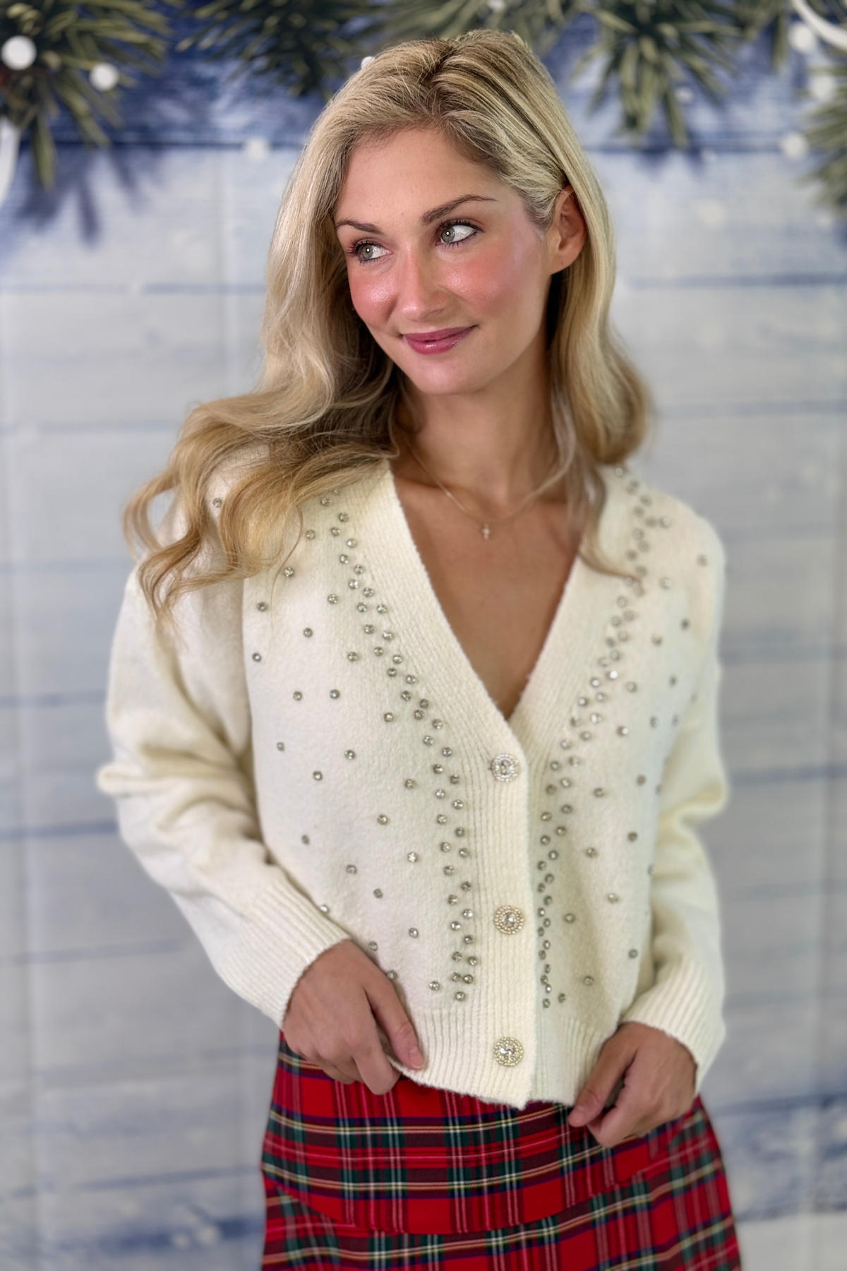 Ivory Christmas cardigan styled with red plaid pants