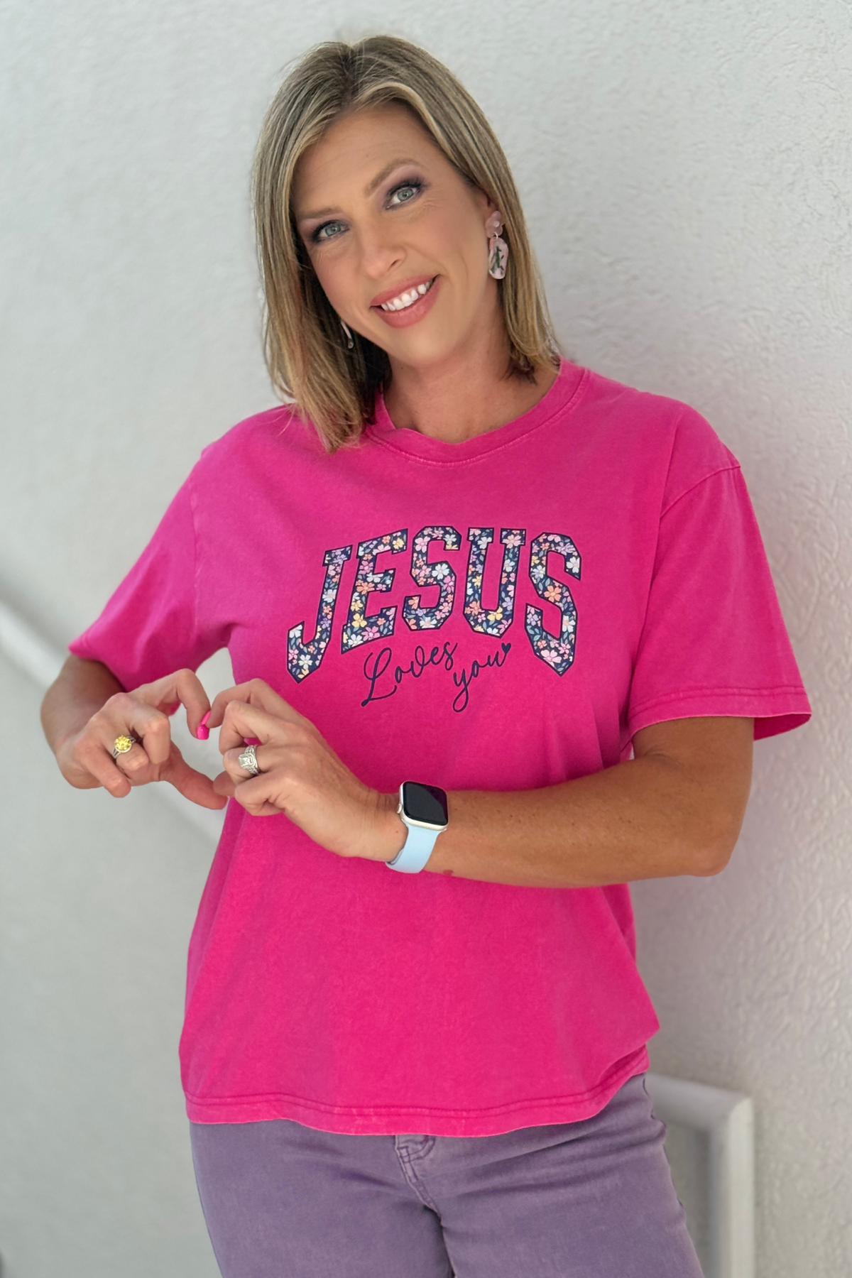 Hot pink Jesus Loves You graphic tee with floral lettering