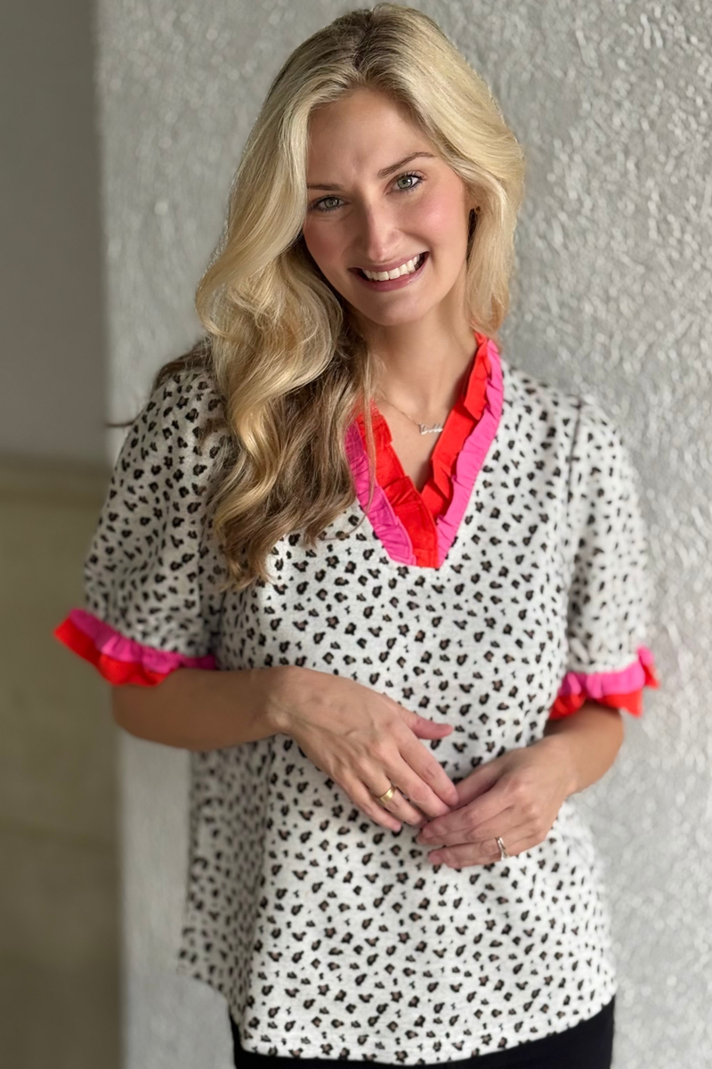 Model wearing Bold & Bright Ruffle Trim Top with ruffle neckline and sleeve detail