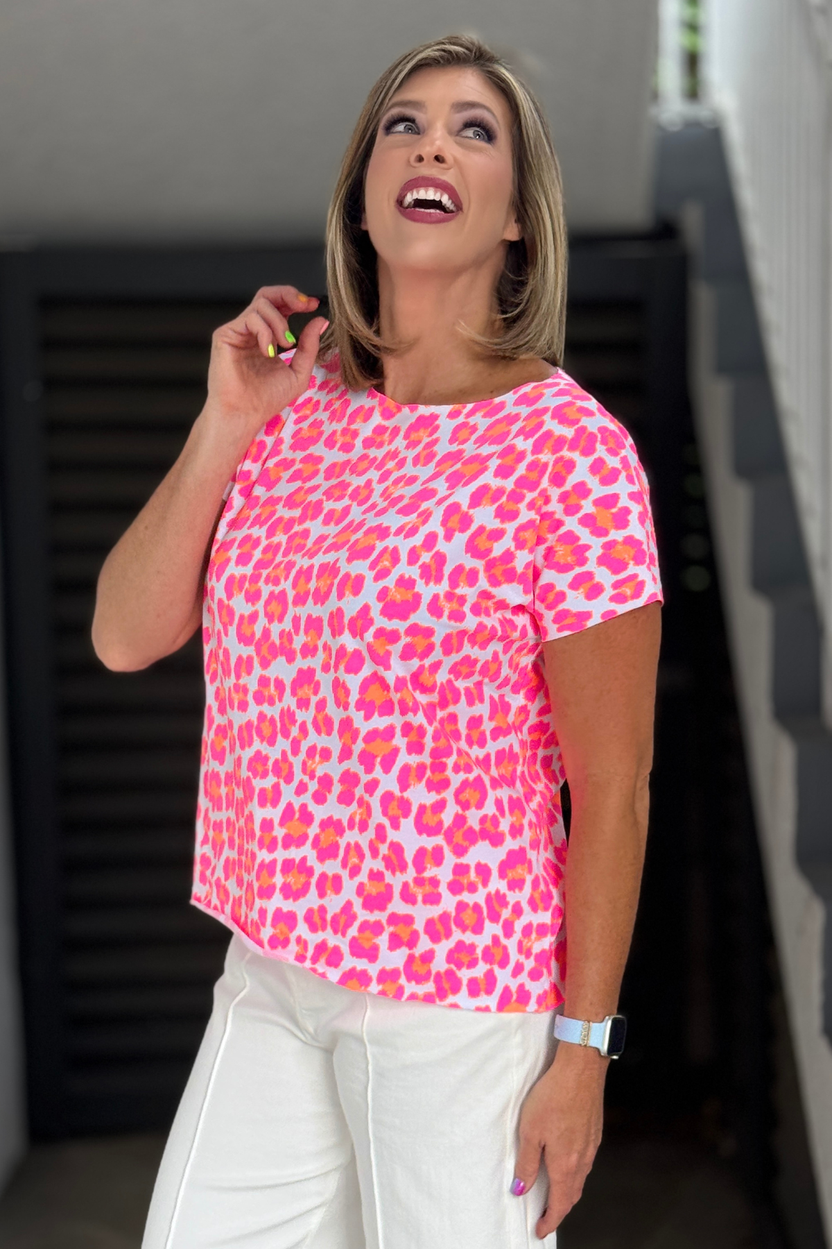 Colorful pink and coral leopard print boutique blouse styled with white pants