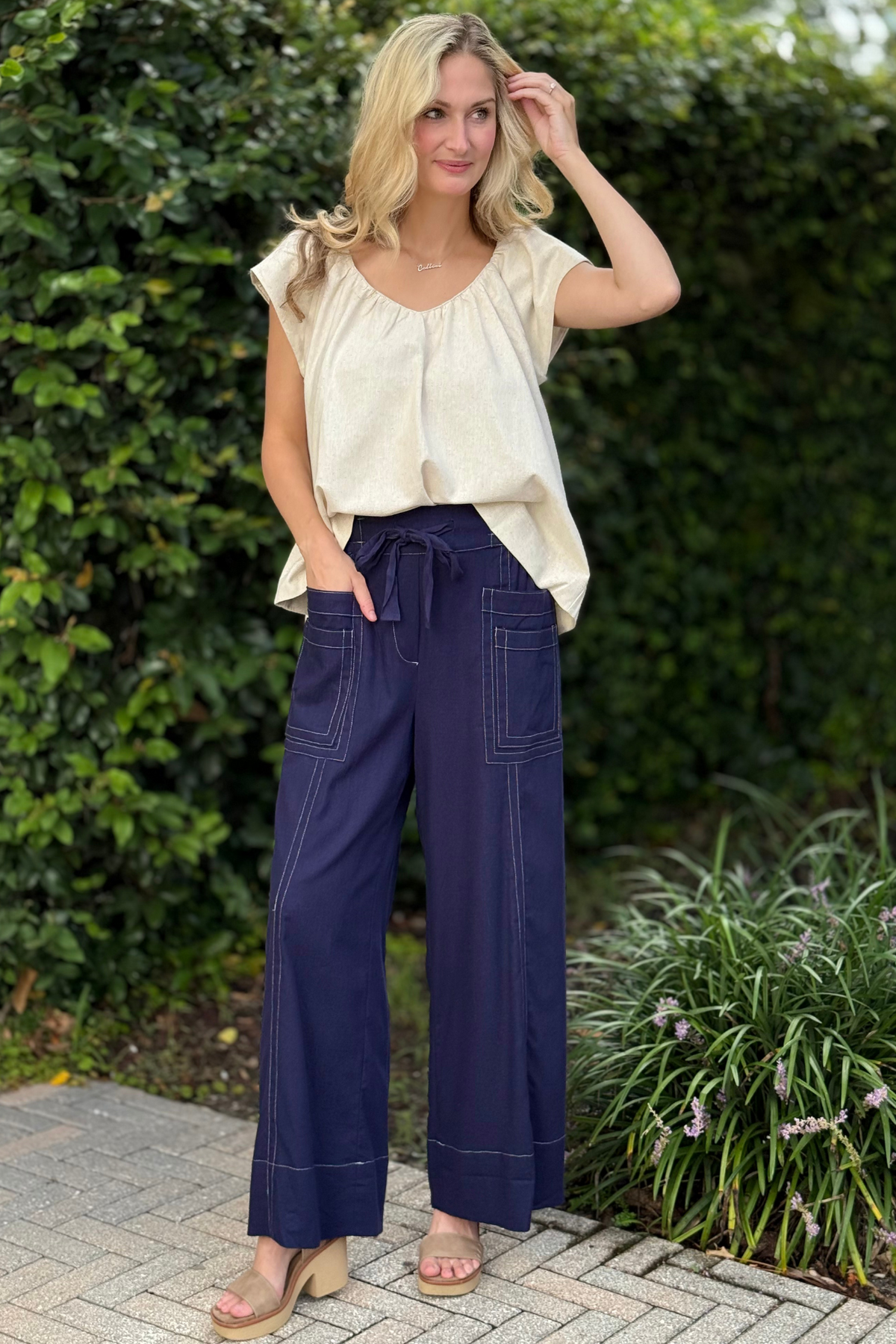 Woman wearing Hudson Stitch Wide Leg Pants in navy linen with oversized patch pockets, tie waist, and contrast stitching.