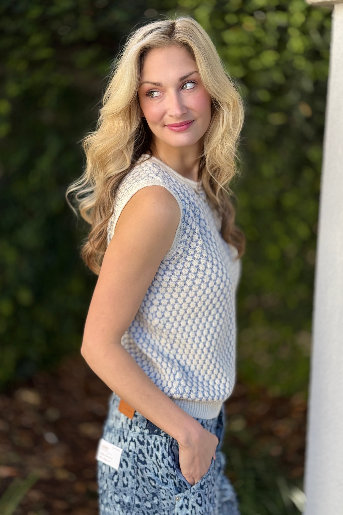 Women’s boutique knit sleeveless sweater styled with wide leg denim