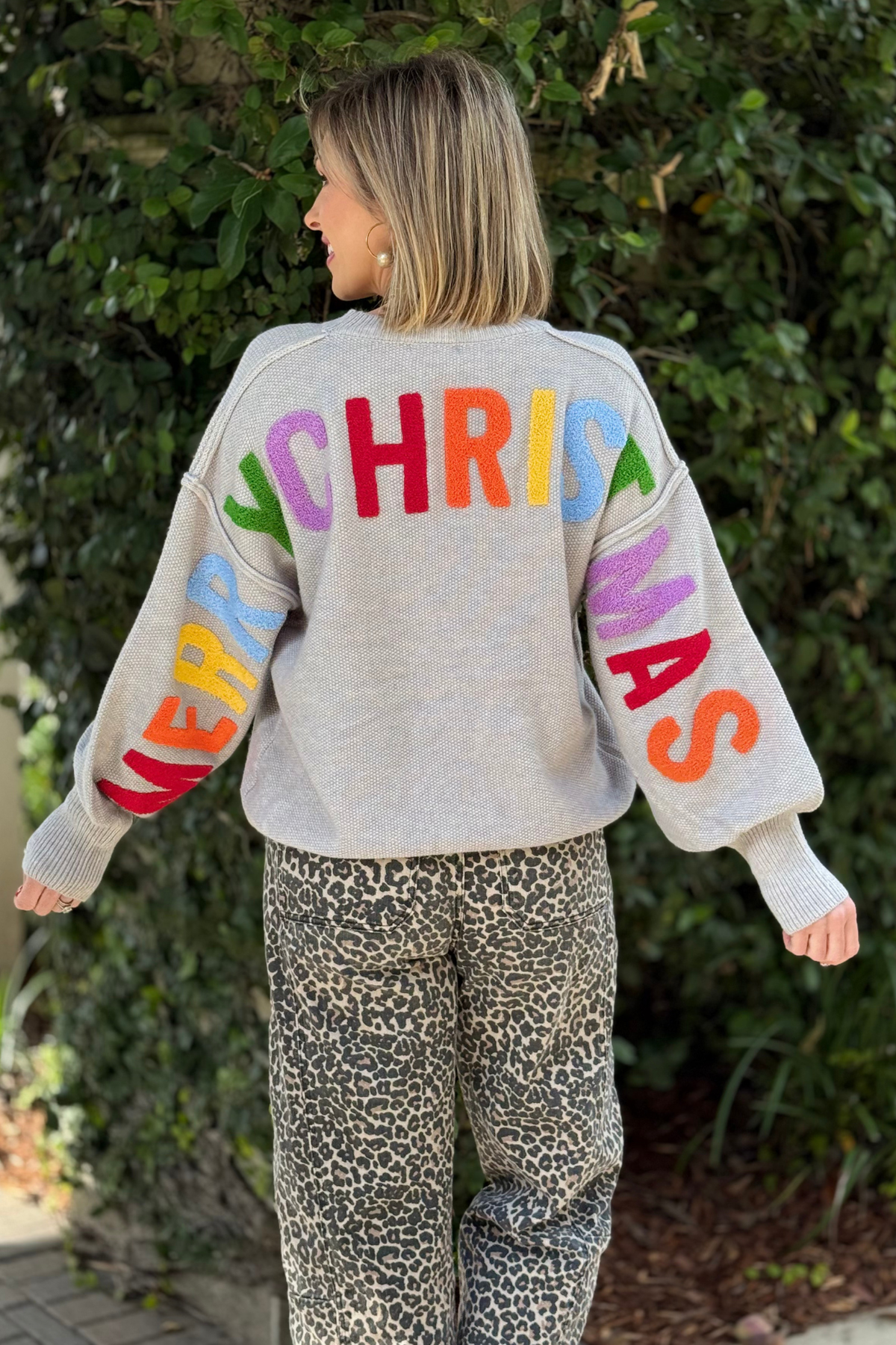 Back view of grey Merry Christmas chenille letter sweater