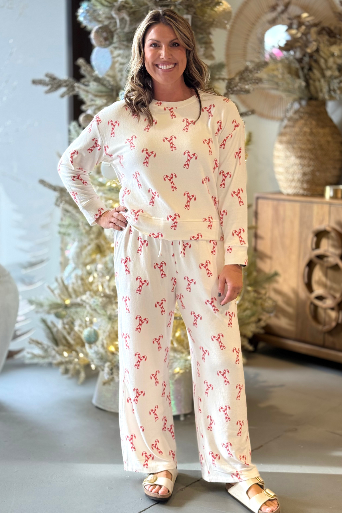 Woman wearing white Mary Square candy cane pajama set featuring long sleeve top and drawstring wide-leg pants