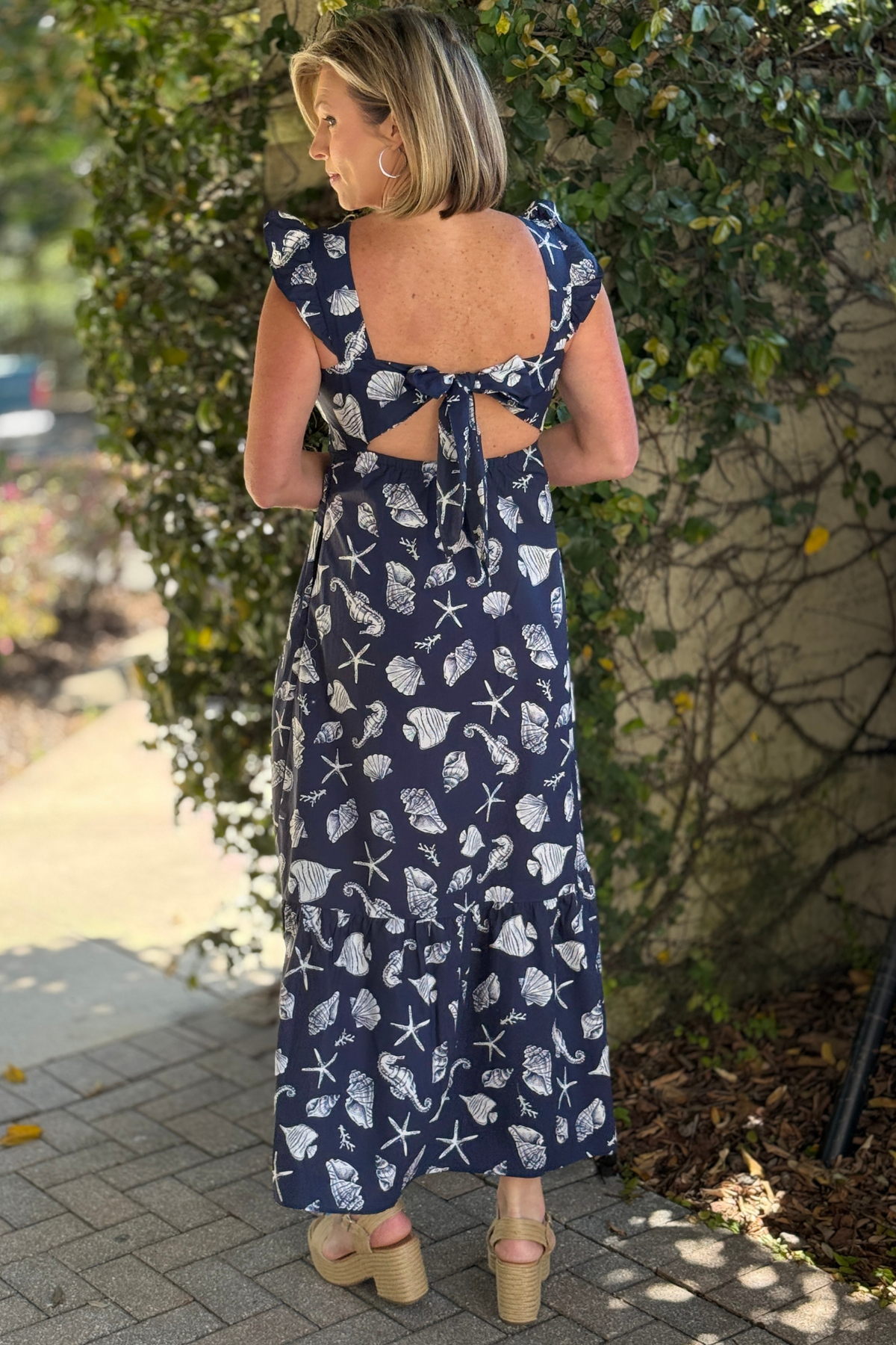 Back view of seashell print dress with tie detail and cutout