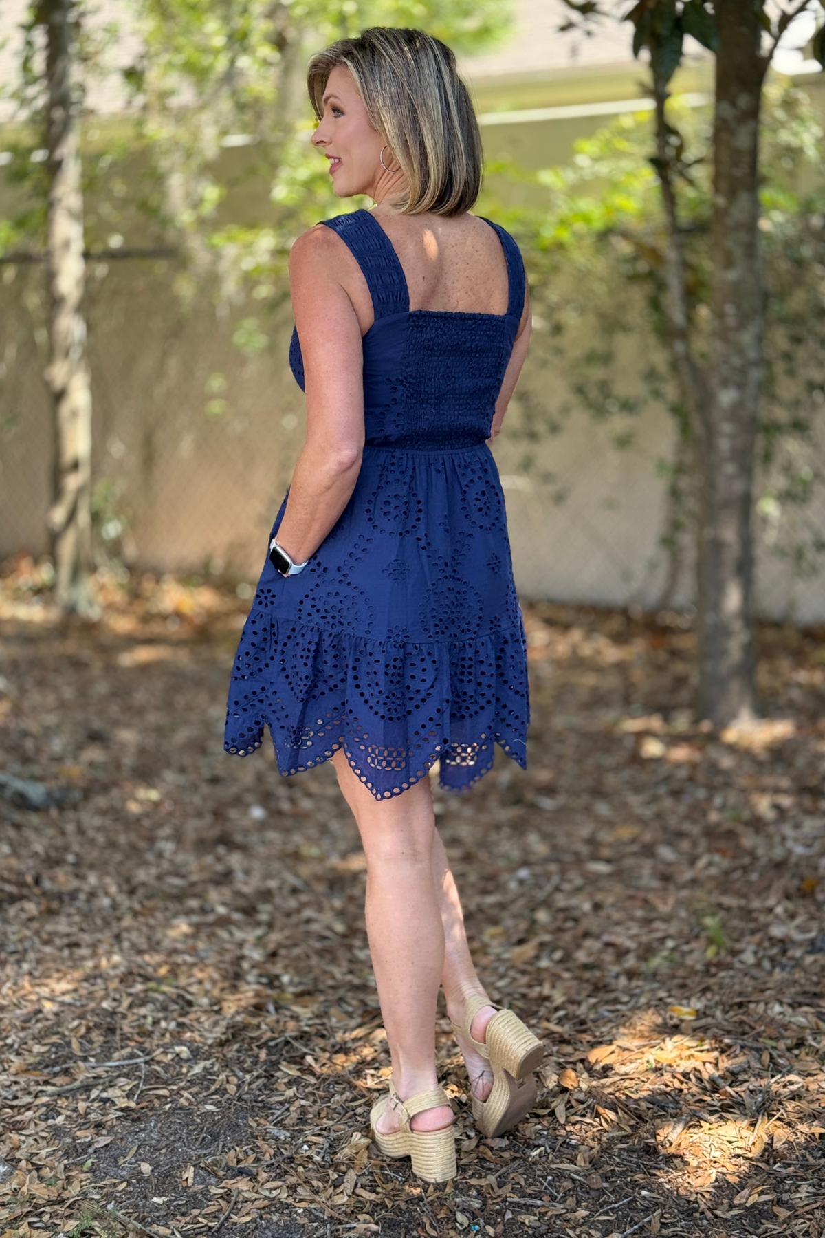 Side view of navy eyelet dress with smocked straps and elastic waist